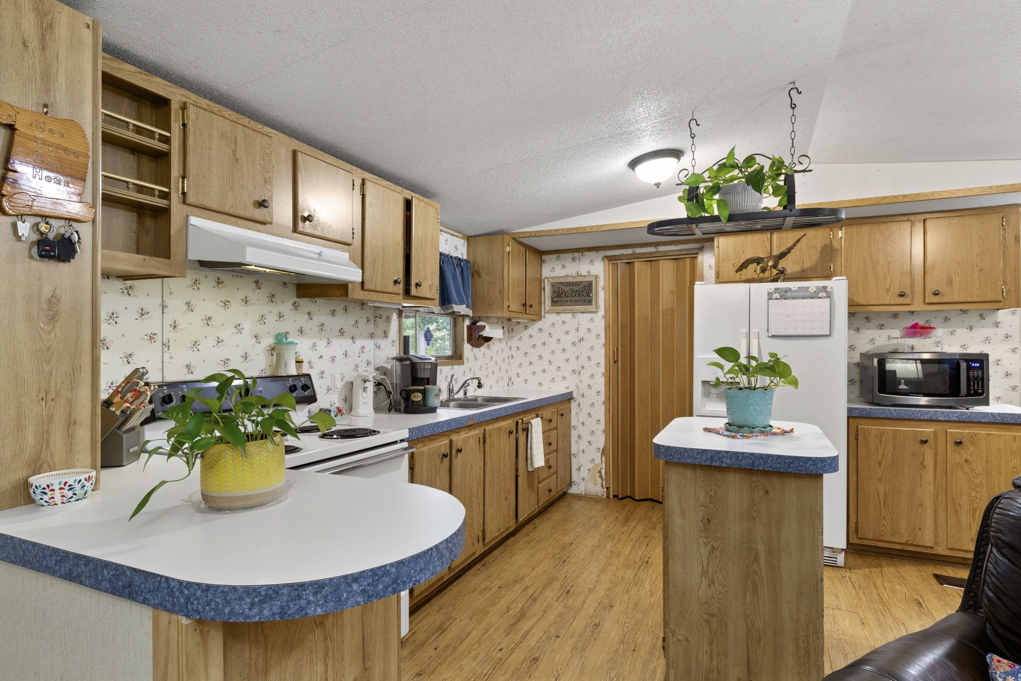 The light and bright island kitchen offers plenty of storage, with a convenient indoor utility room located just beyond the kitchen.