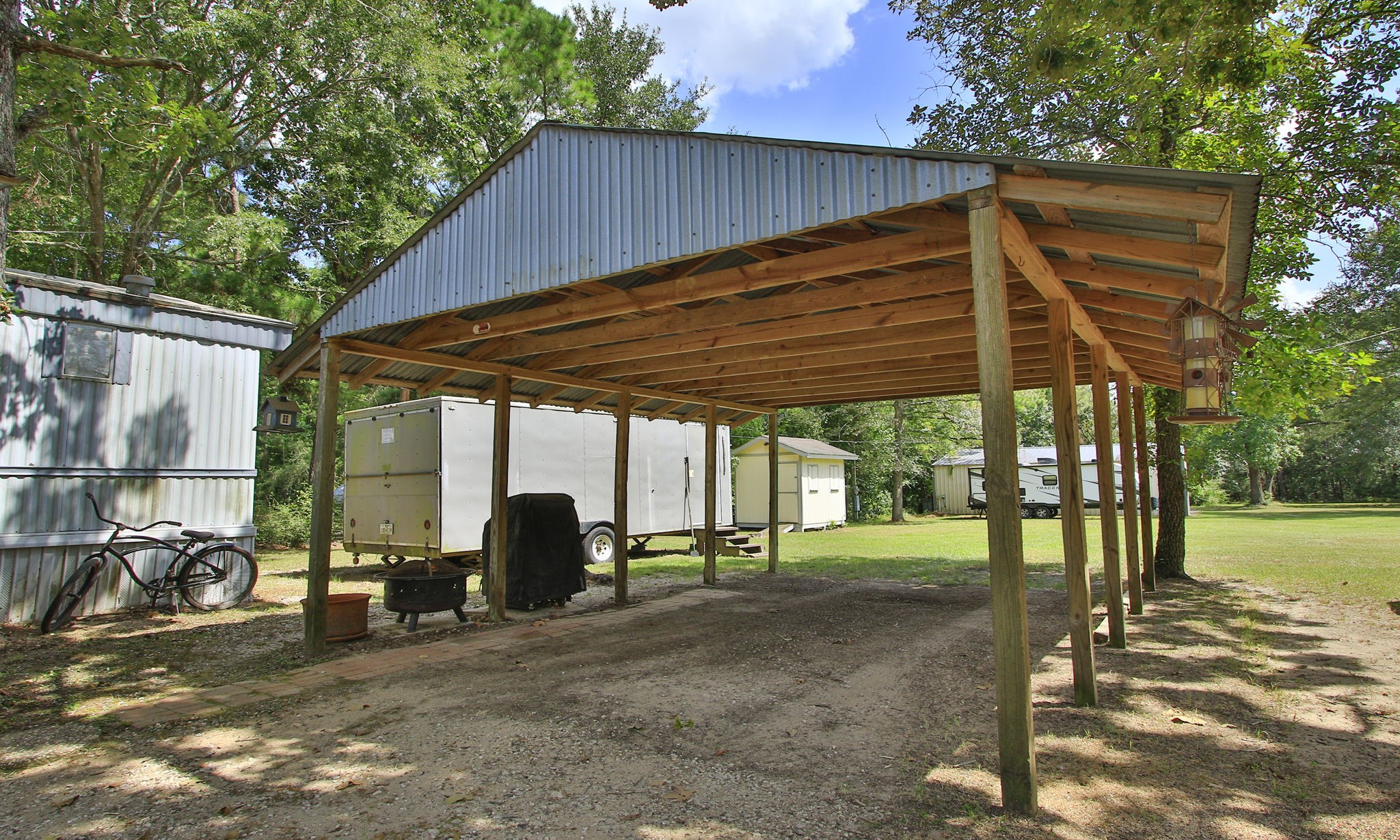 The property includes a covered carport, with an additional building toward the back left that can be used for storage or as a chicken coop.