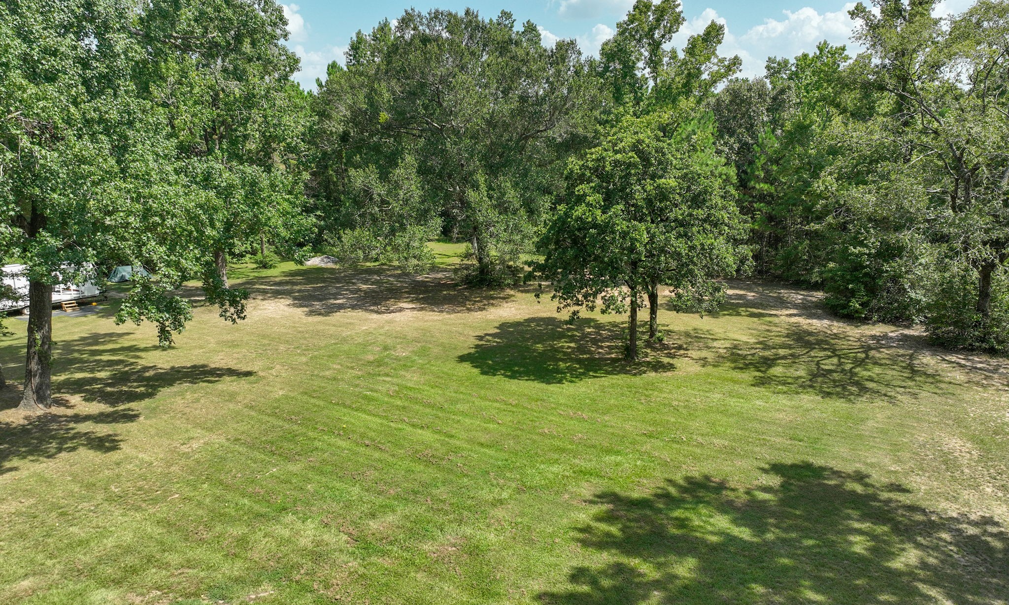 5 ACRES - Expansive, lush green lawn surrounded by mature trees offers a serene and private setting, perfect for outdoor activities and relaxation. Land extends into the back treeline. 5 ACRES - Expansive, lush green lawn surrounded by mature trees offers a serene and private setting, perfect for outdoor activities and relaxation. Land extends into the back treeline.