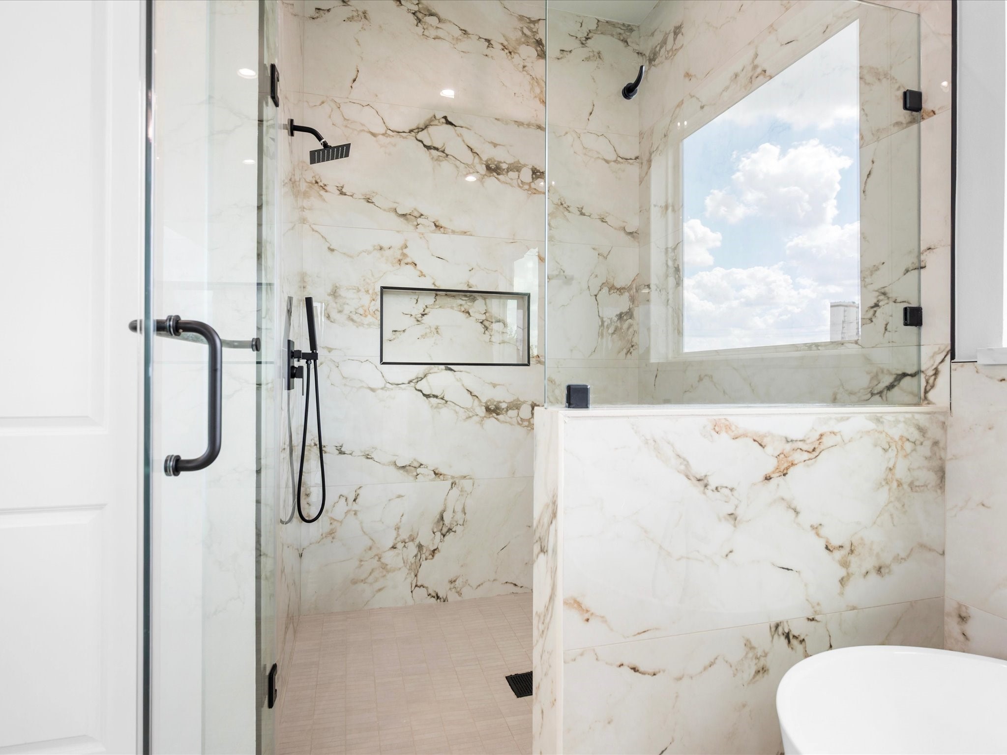 Beautifully detailed tilework elevates the primary shower, adding a refined touch to the ensuite.