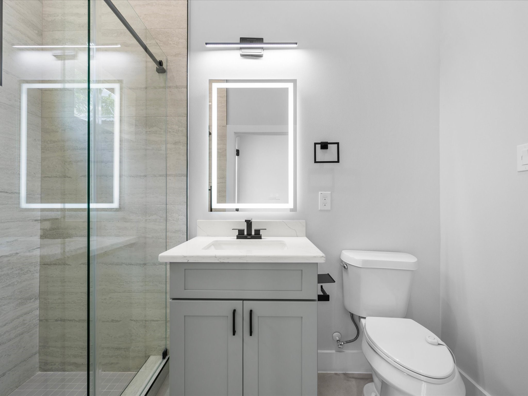Modern finishes and carefully selected details carry the home's contemporary aesthetic into the secondary bathroom, providing a private space for residents and guests.