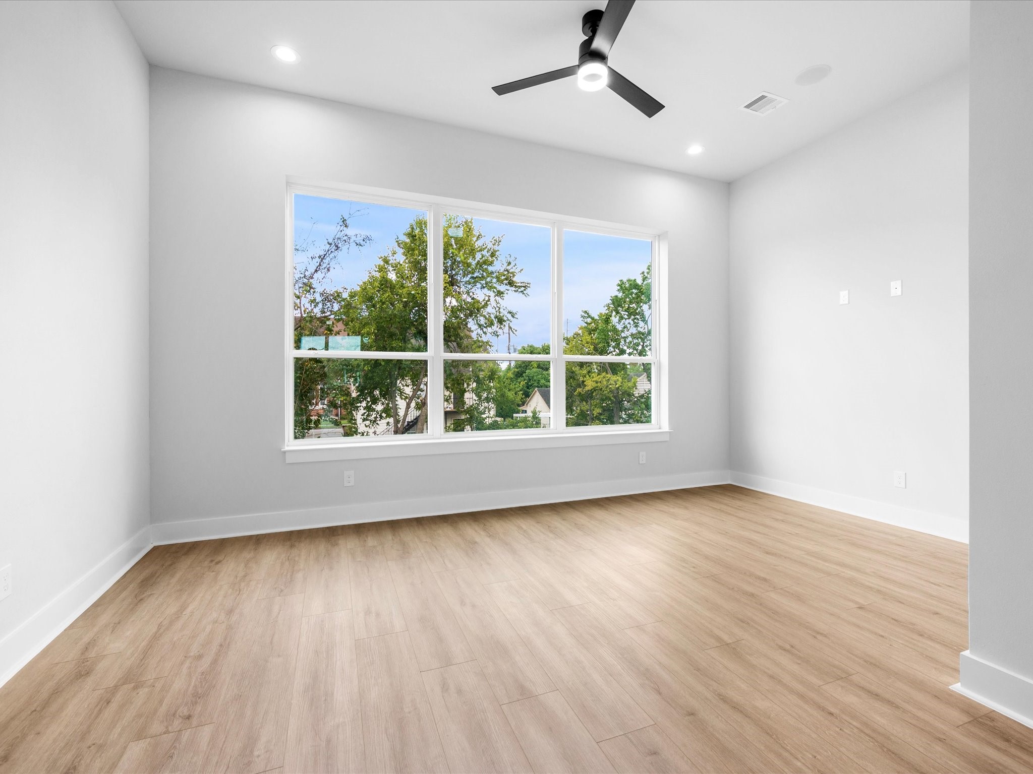 Expansive windows bring natural light into the living area, creating a bright, inviting space that complements the home's clean lines and modern design