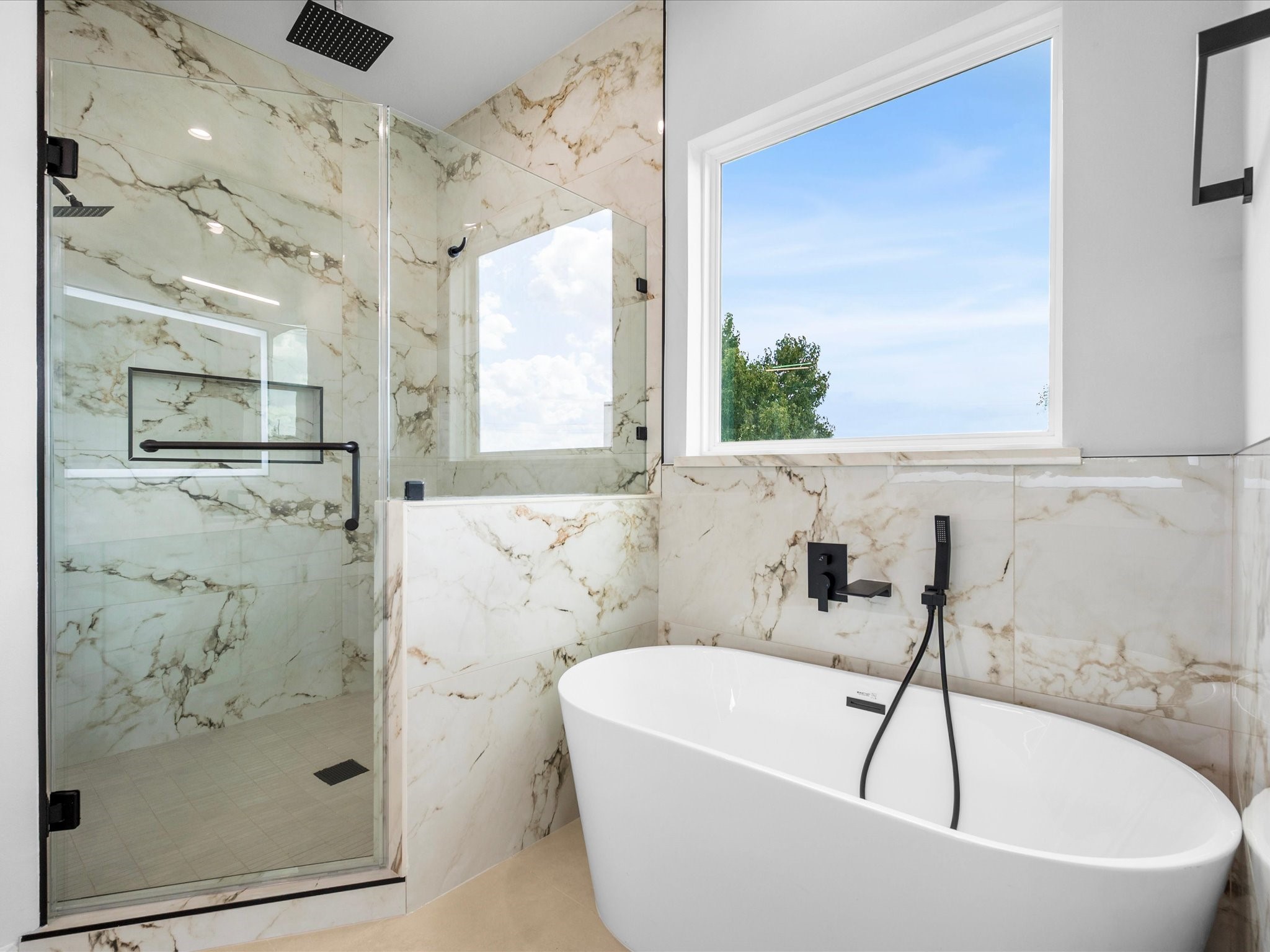 A beautiful soaking tub creates an inviting place to unwind, while refined tilework and contemporary fixtures elevate the primary bathroom.