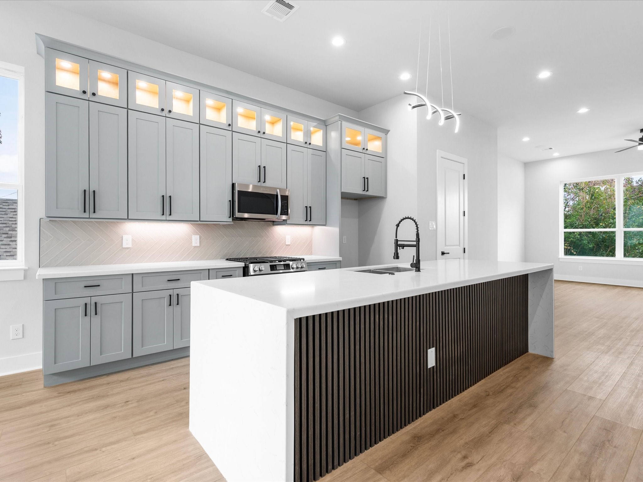 Quartz countertops and streamlined cabinetry contribute to the kitchen's clean, modern aesthetic, creating a sophisticated backdrop for daily routines and hosting guests.
