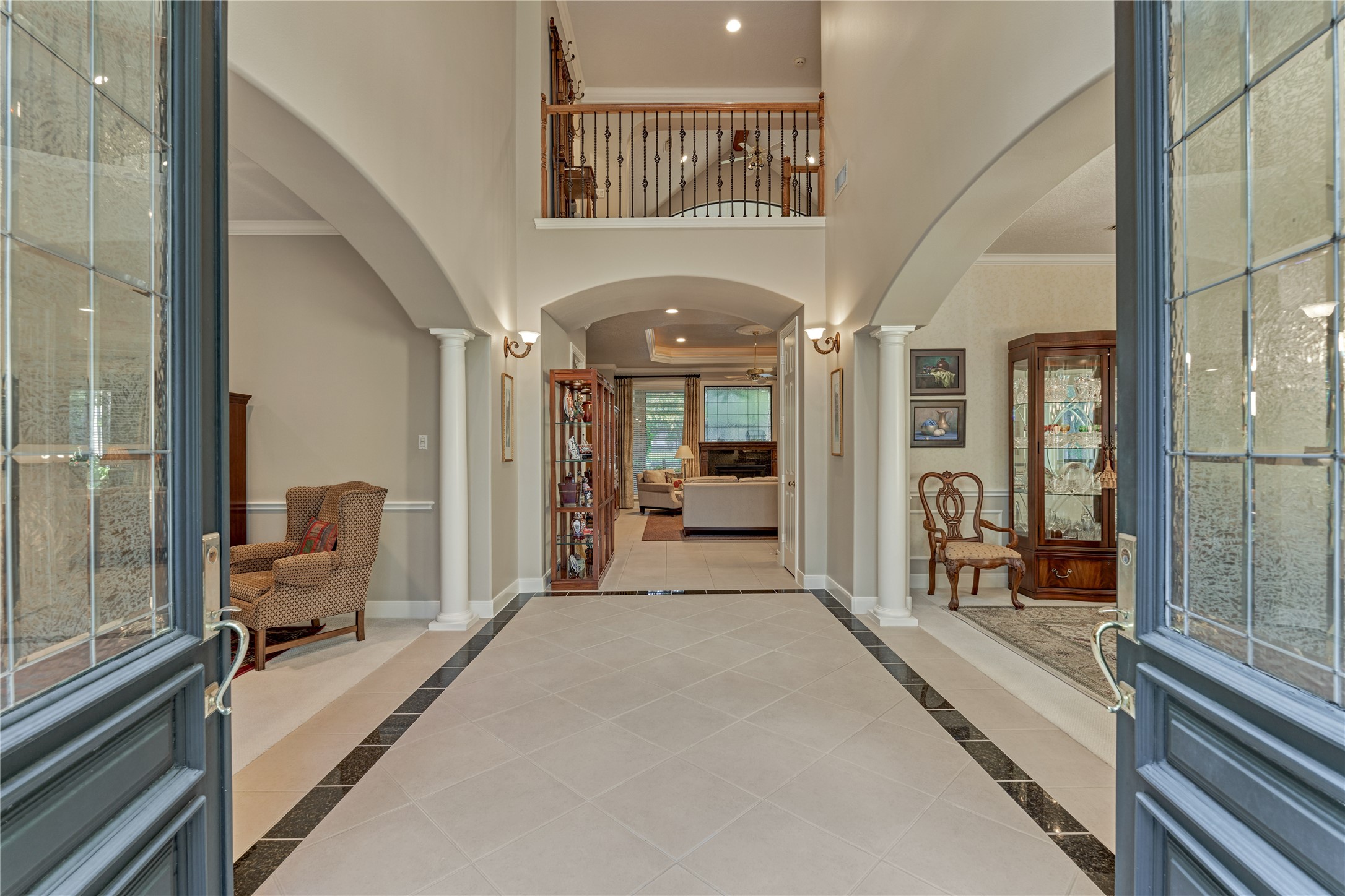 The grand two-story foyer is flanked by dining and living formals.