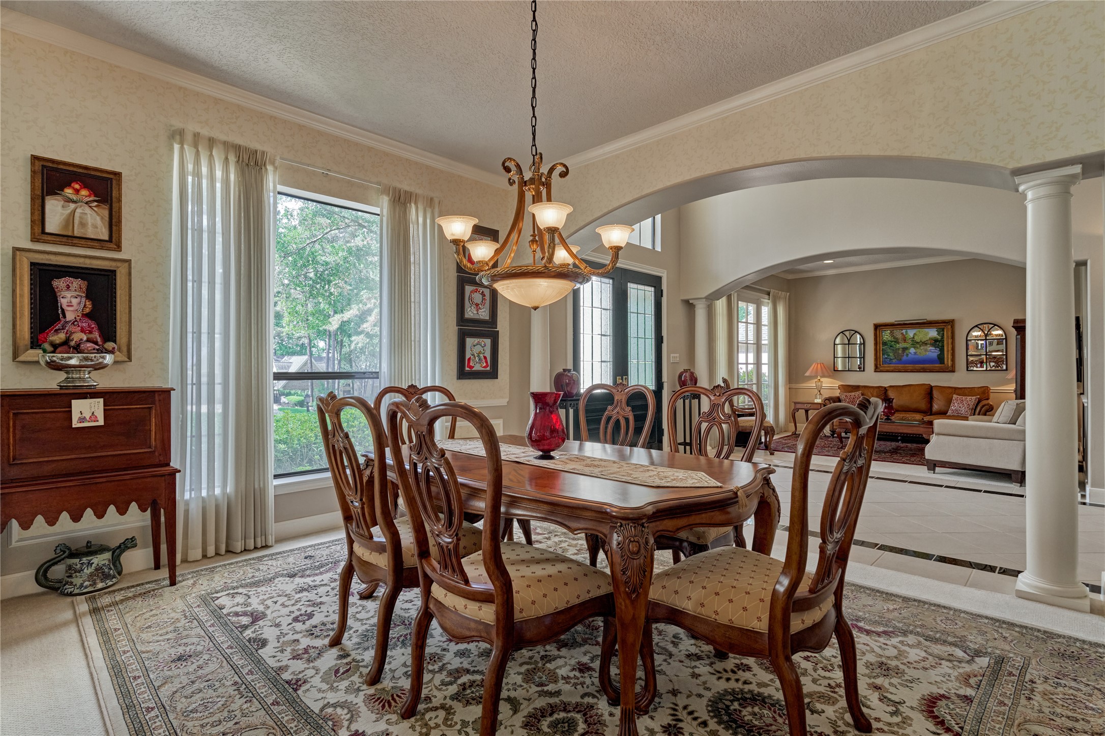 Formal dining room with elegant lighting and huge picture window.