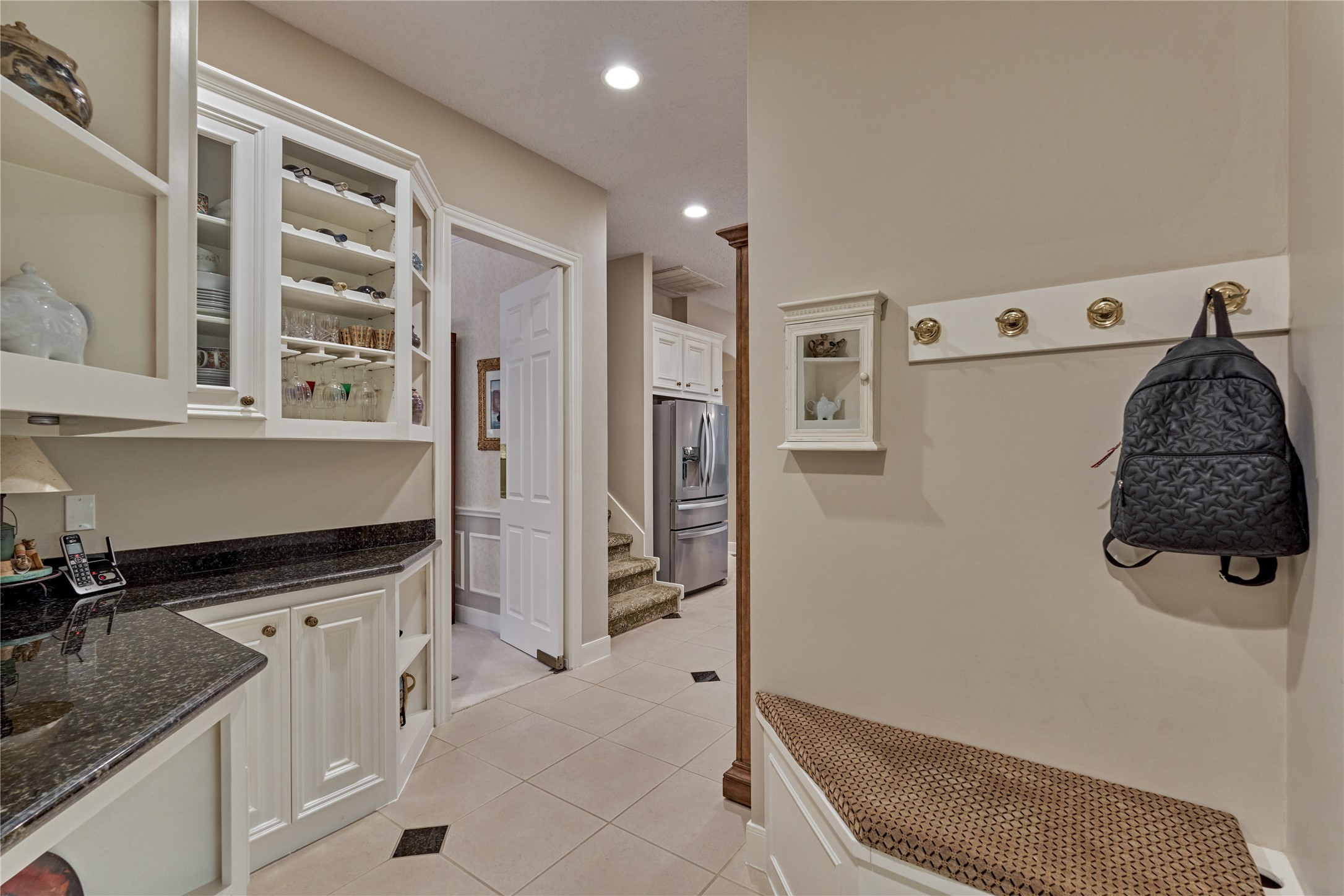 Mud area just off garage entrance leads to butler pantry and kitchen. Stairs to second level are between dining room and kitchen.