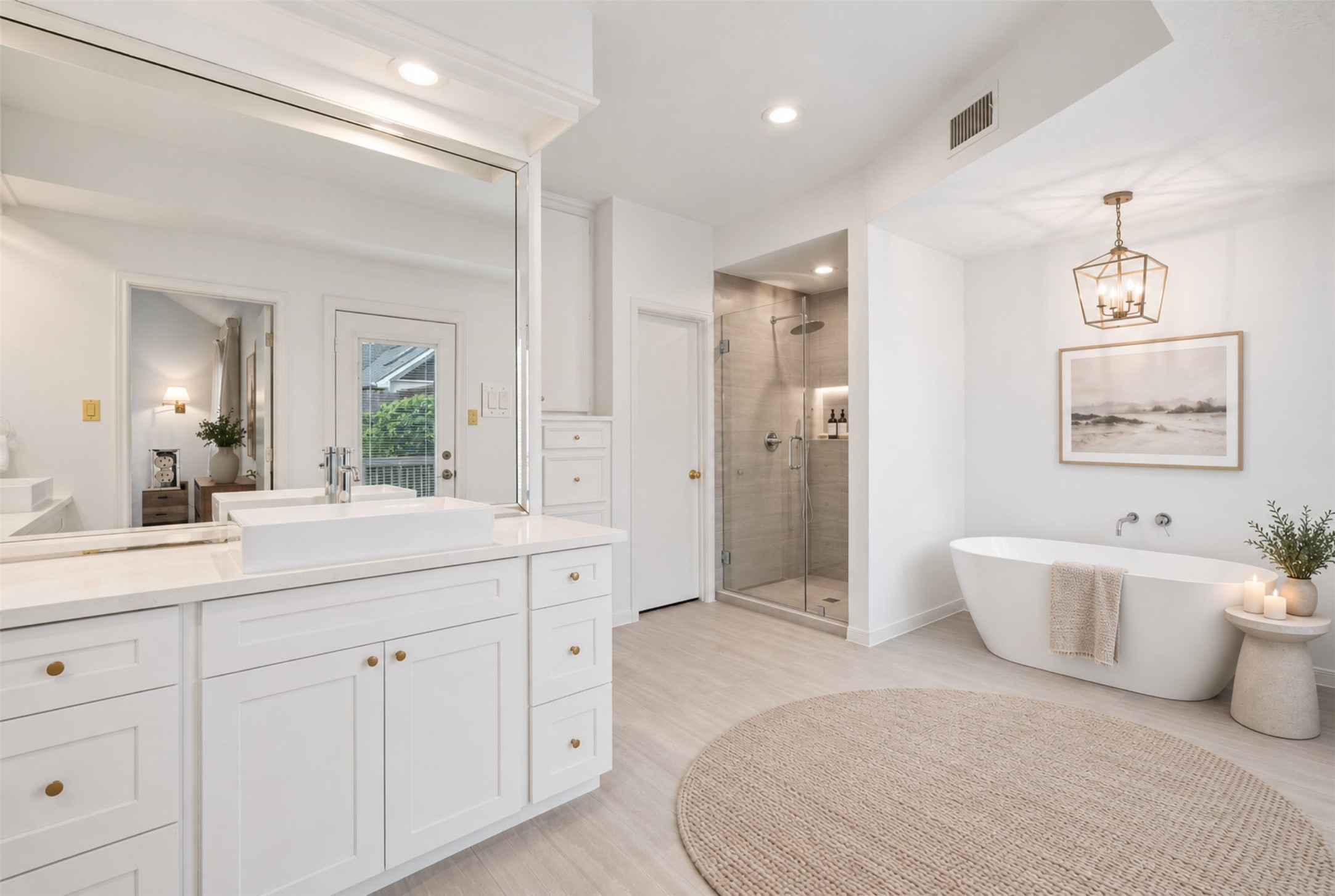 Indulge in a spa-like retreat in this spacious bathroom, featuring a sleek glass-enclosed shower, an elegant freestanding soaking tub, and expansive windows that fill the space with natural light. (Virtually Staged)