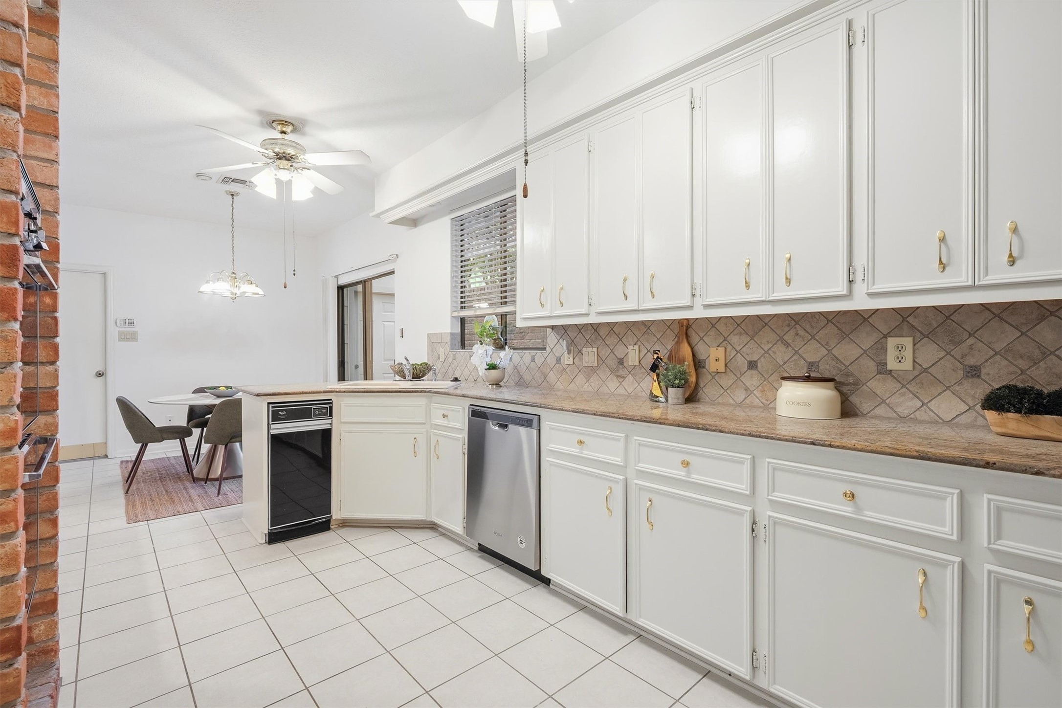 Spacious kitchen with elegant white cabinetry, modern appliances, and a cozy dining area, perfect for family gatherings.