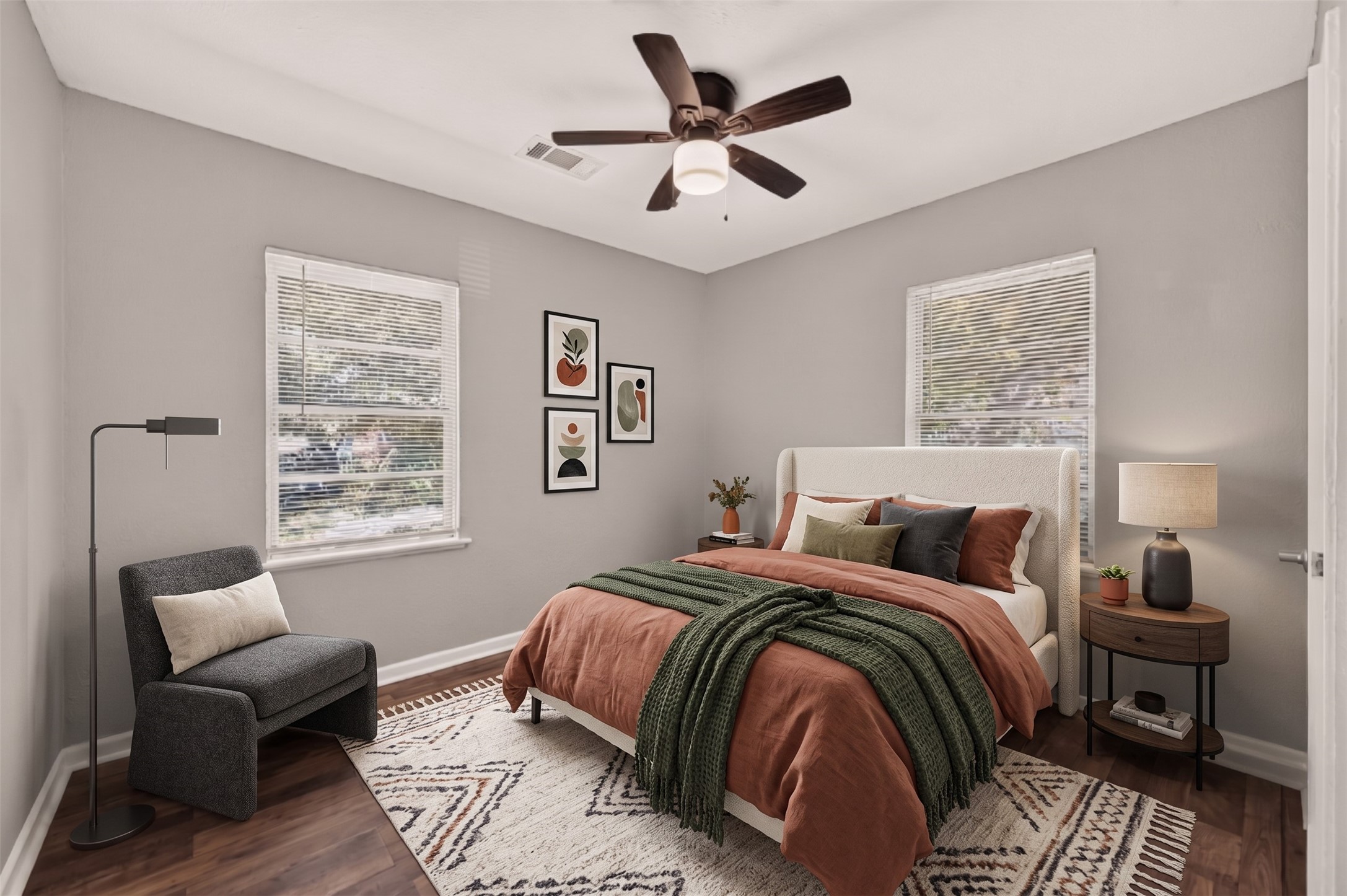 Bedroom 2 with windows on two walls and ceiling fan. (Virtually staged)