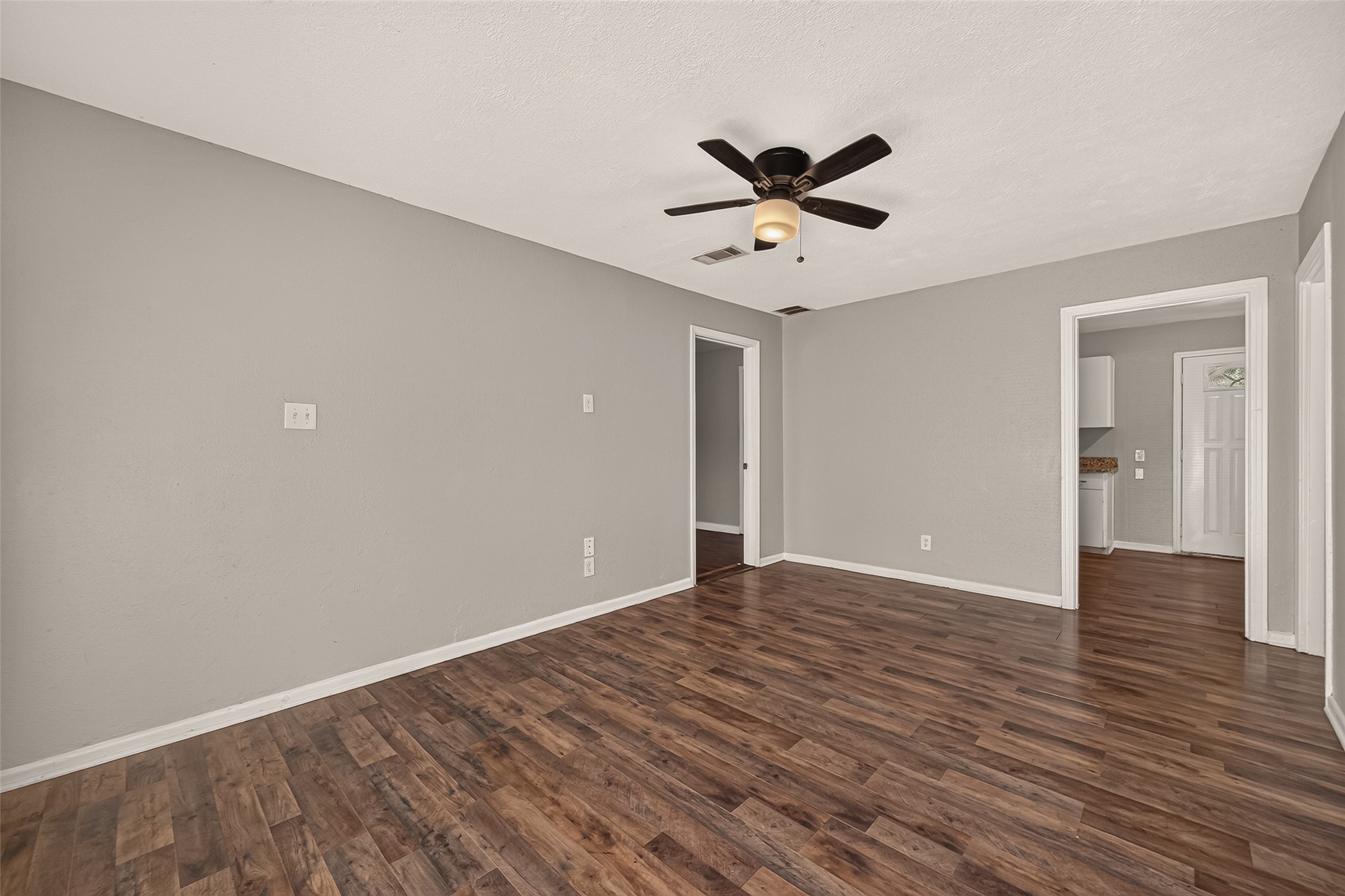 Living room, unfurnished, open to the kitchen and hallway.