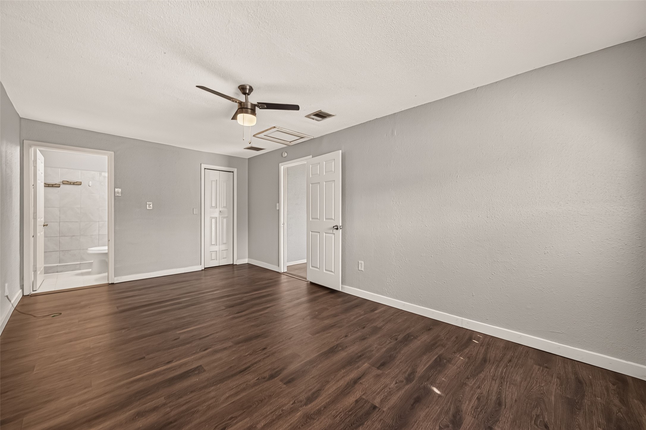 Primary bedroom, unfurnished, with en-suite bath, closet, and hall access.