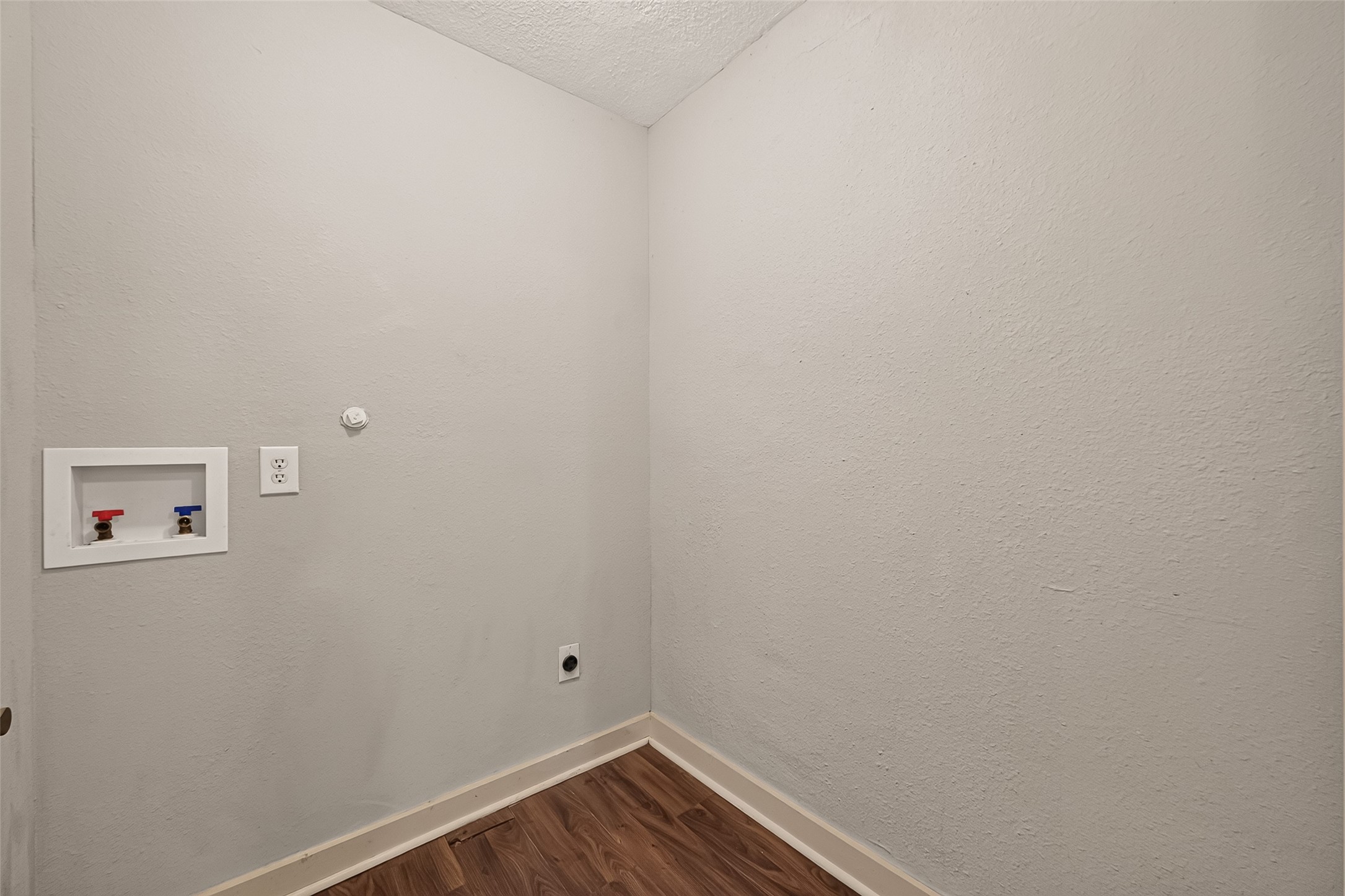 Utility room with washer and dryer connections.