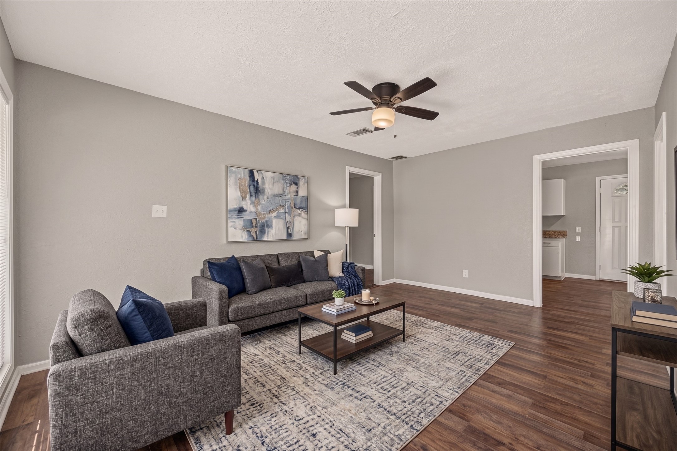 Welcome to 5935 Beldart St. The living room has wood-look vinyl flooring, a ceiling fan, and a view through to the kitchen. (Virtually staged) Welcome to 5935 Beldart St. The living room has wood-look vinyl flooring, a ceiling fan, and a view through to the kitchen. (Virtually staged)