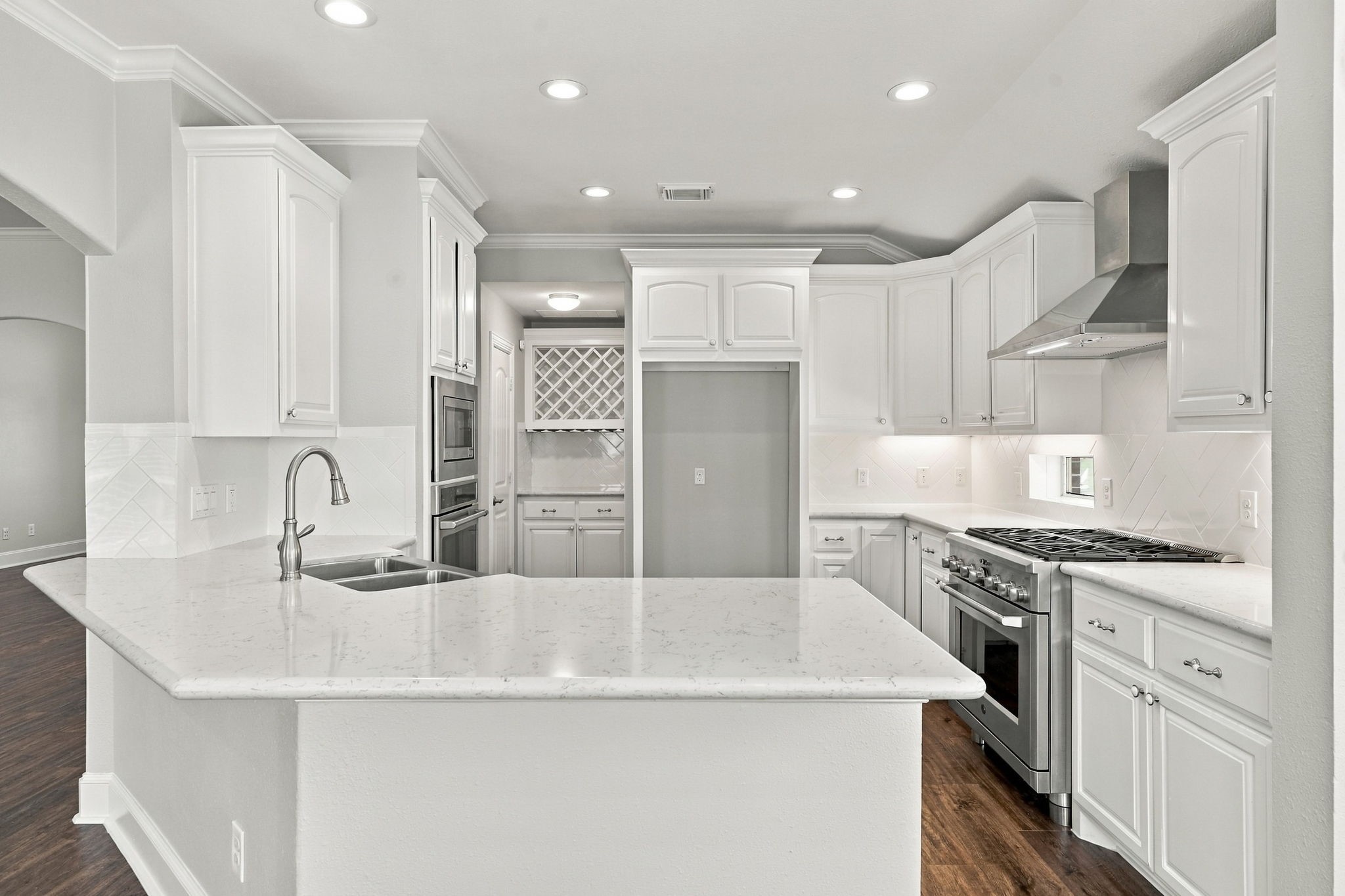 This view showcases the entire Kitchen and all of its beautiful features, from the stylish finishes to the thoughtfully designed layout. In the distance, you can catch a glimpse of the Butlers Pantry, offering the perfect space for storing and displaying your favorite wine, serving pieces, and additional kitchen essentials.