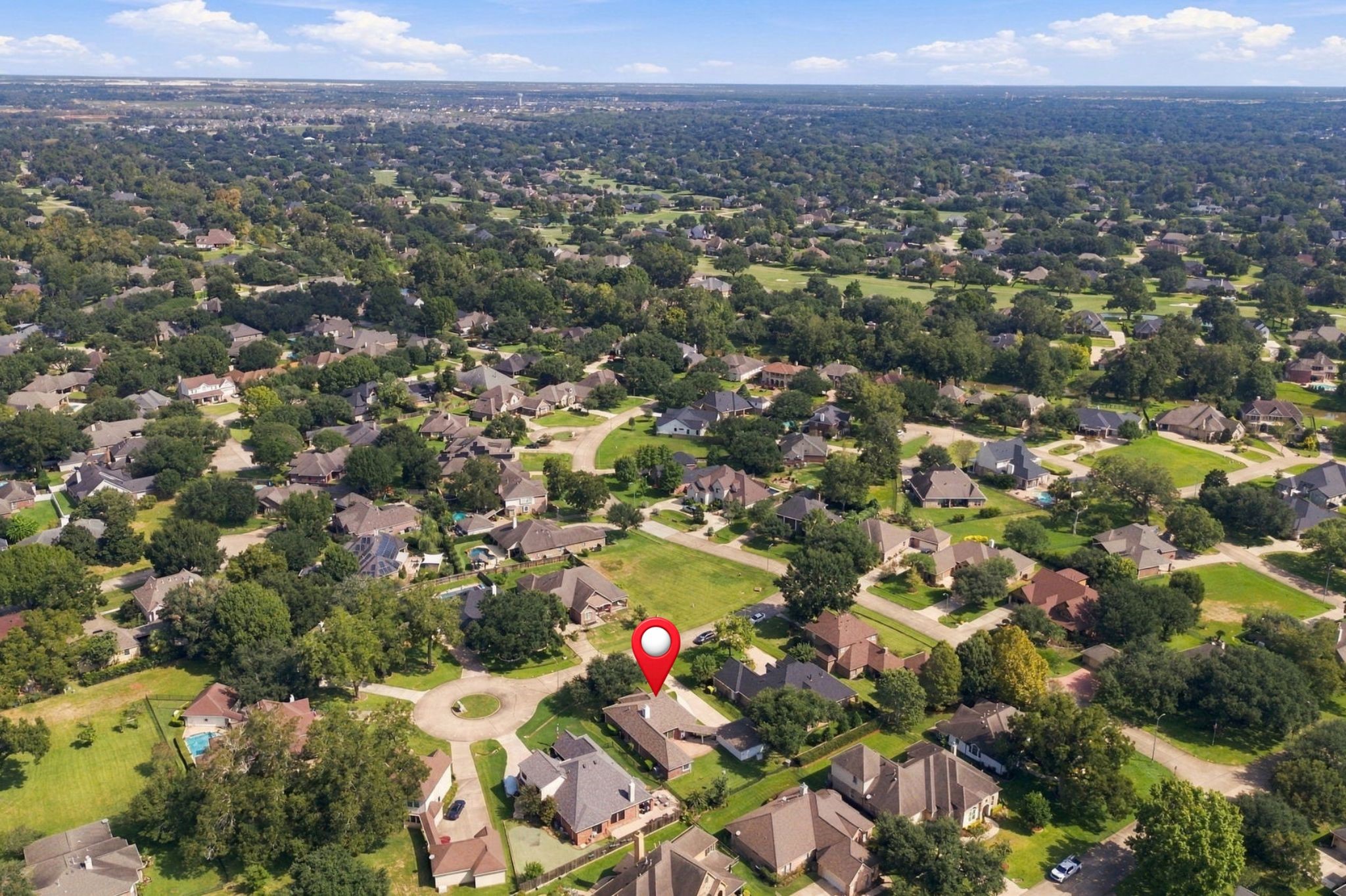 This aerial view looks northeast, showcasing the homes desirable Cul-De-Sac location. In the distance, you can catch a glimpse of the golf course, while the home is pinpointed for easy reference.