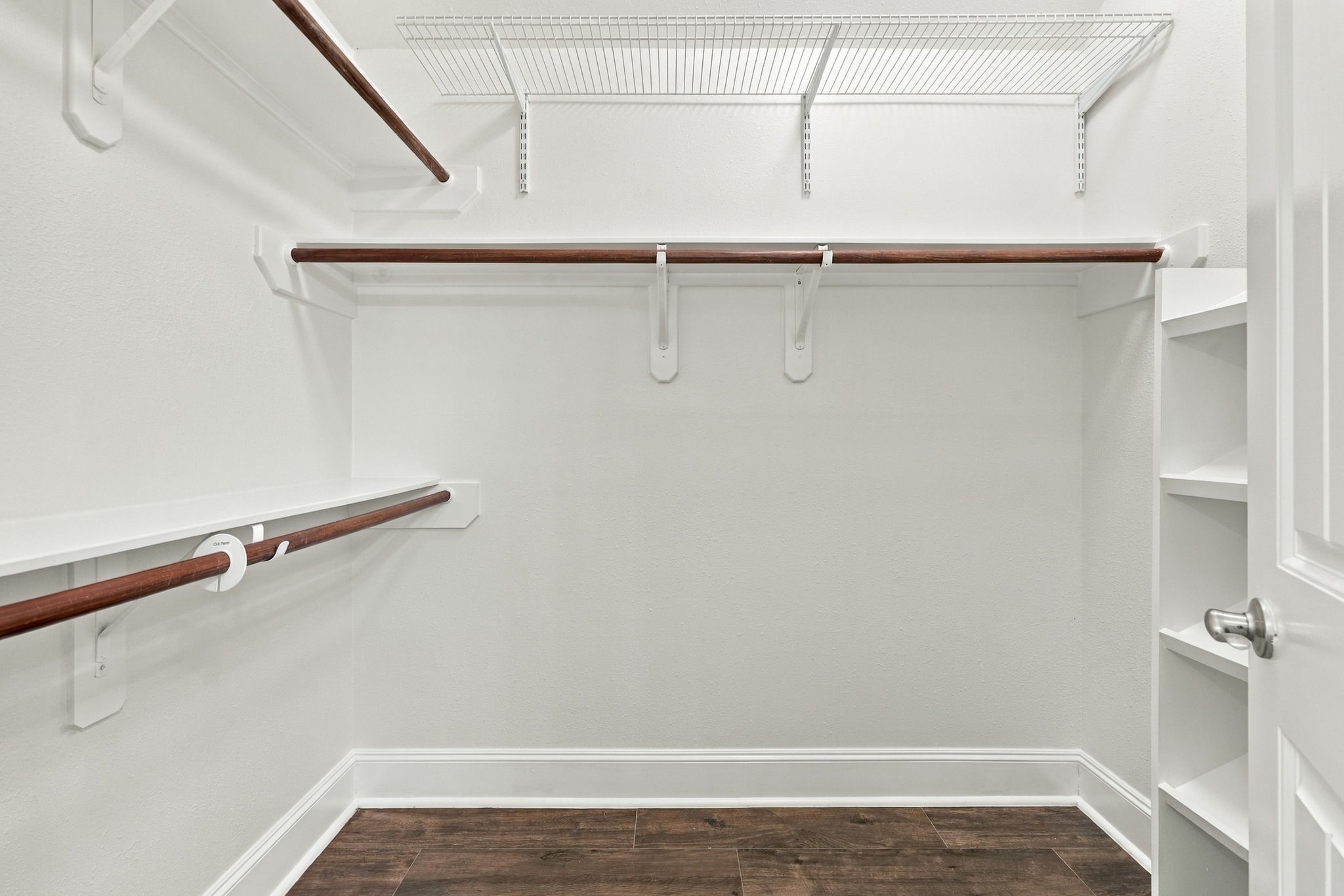Here is the second walk-in closet in the Primary Suite, featuring custom built-ins and an abundance of hanging bars, providing plenty of organized storage for clothing, shoes, and accessories.