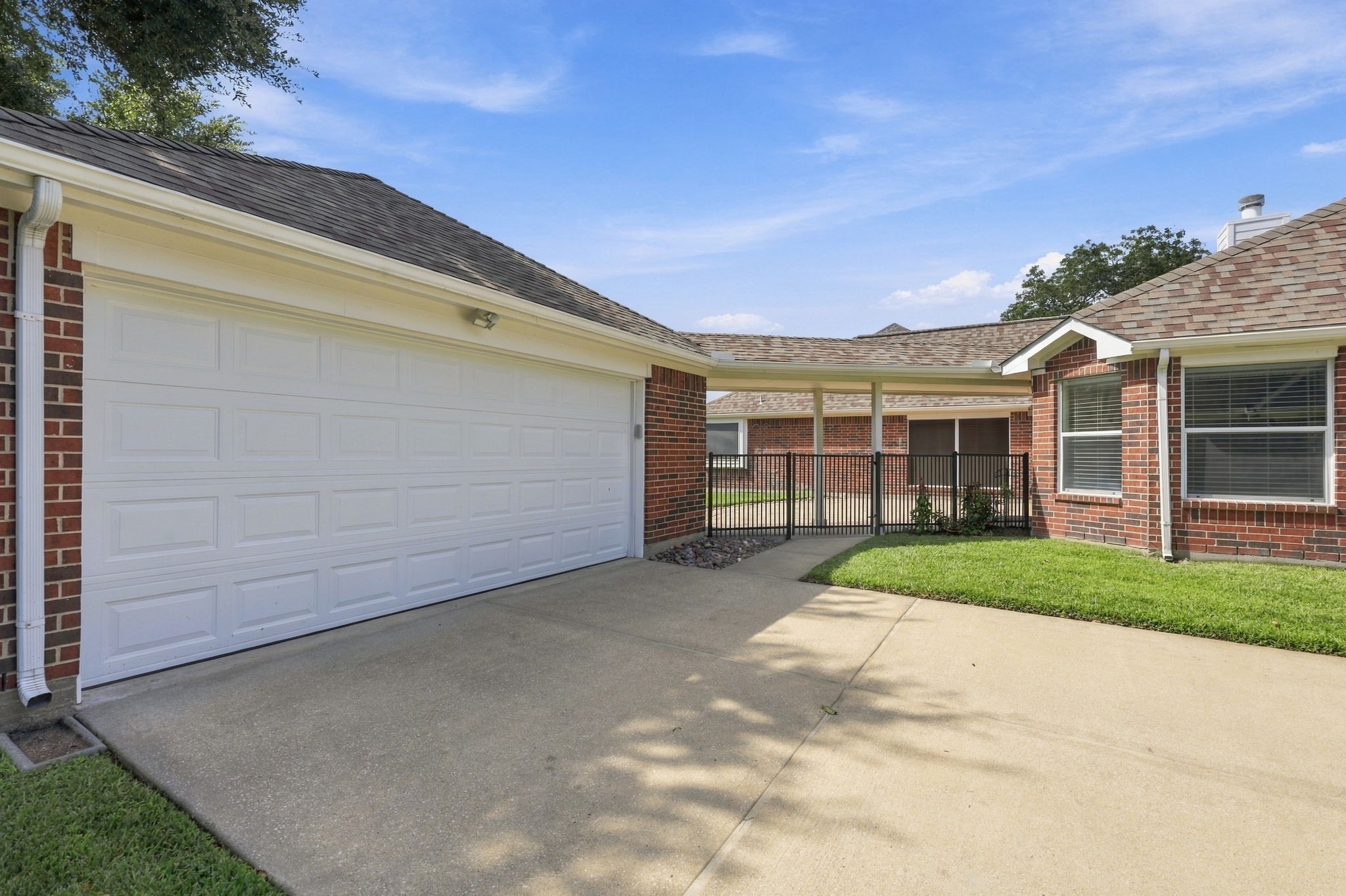 A wrought-iron fence and gate enclose the breezeway leading to the Backyard, providing privacy and security while offering easy access to the spacious back patio area.