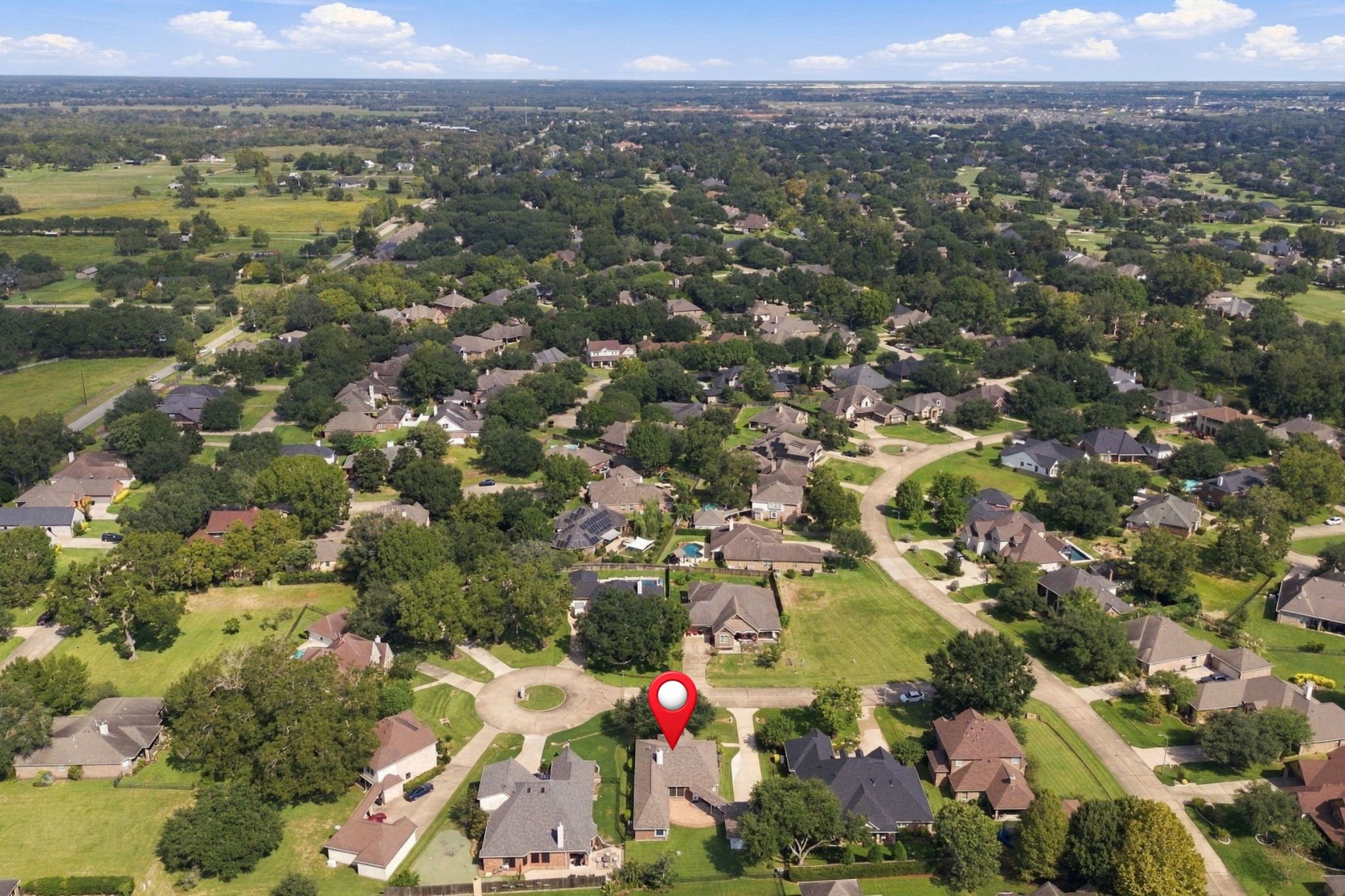 This aerial view looks north, providing a broader perspective of the surrounding area. The home has been pinpointed for easy reference.