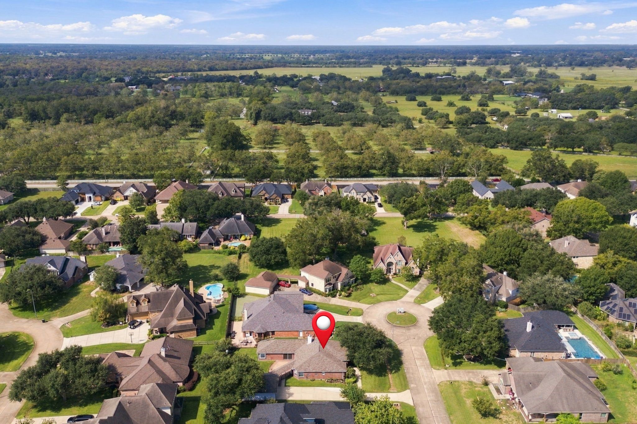 This aerial view looks west, providing a broader perspective of the surrounding area. The home has been pinpointed for easy reference.
