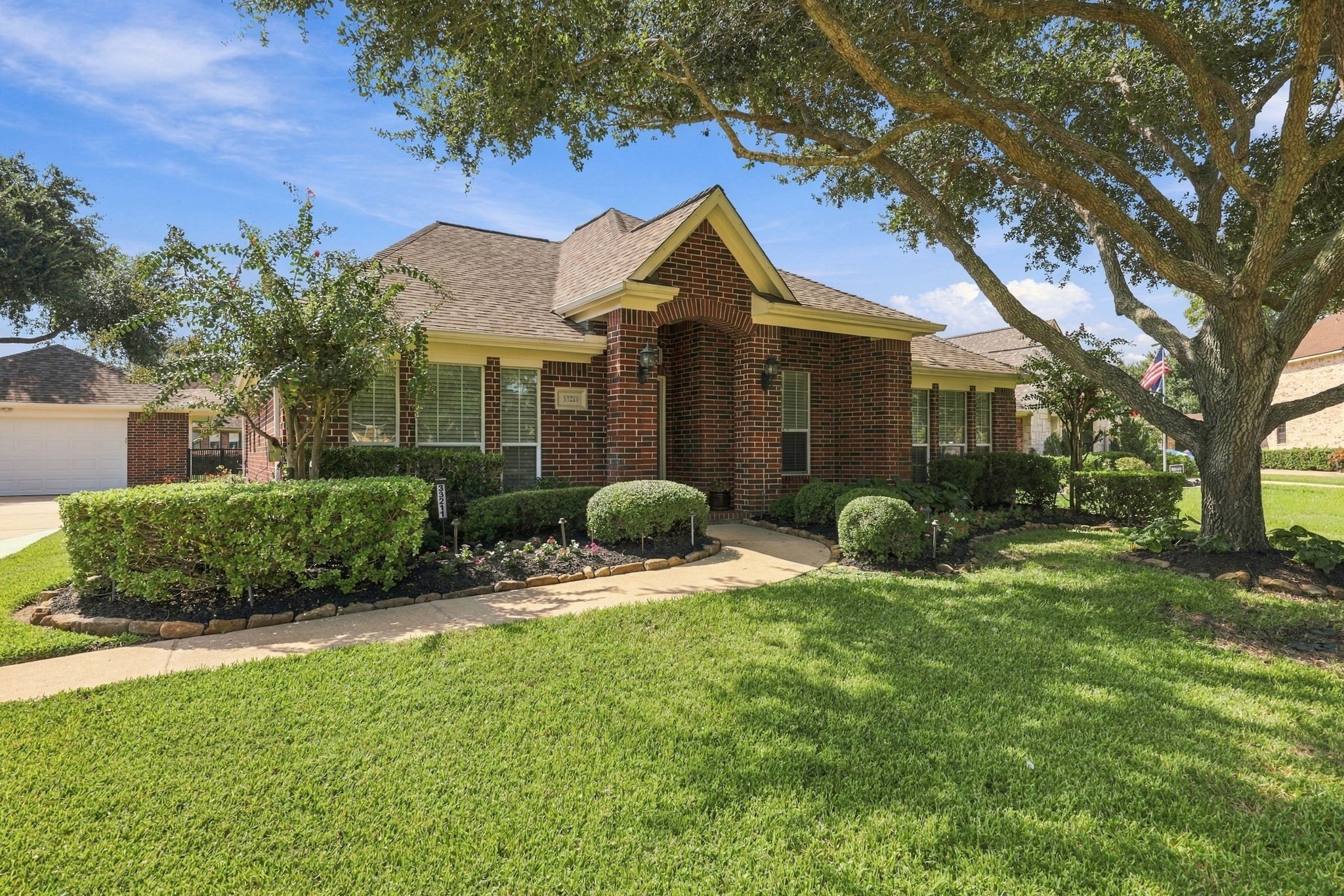 A charming sidewalk leads to the inviting covered Front Porch, creating a welcoming entryway and the perfect spot to enjoy the beautifully landscaped surroundings.