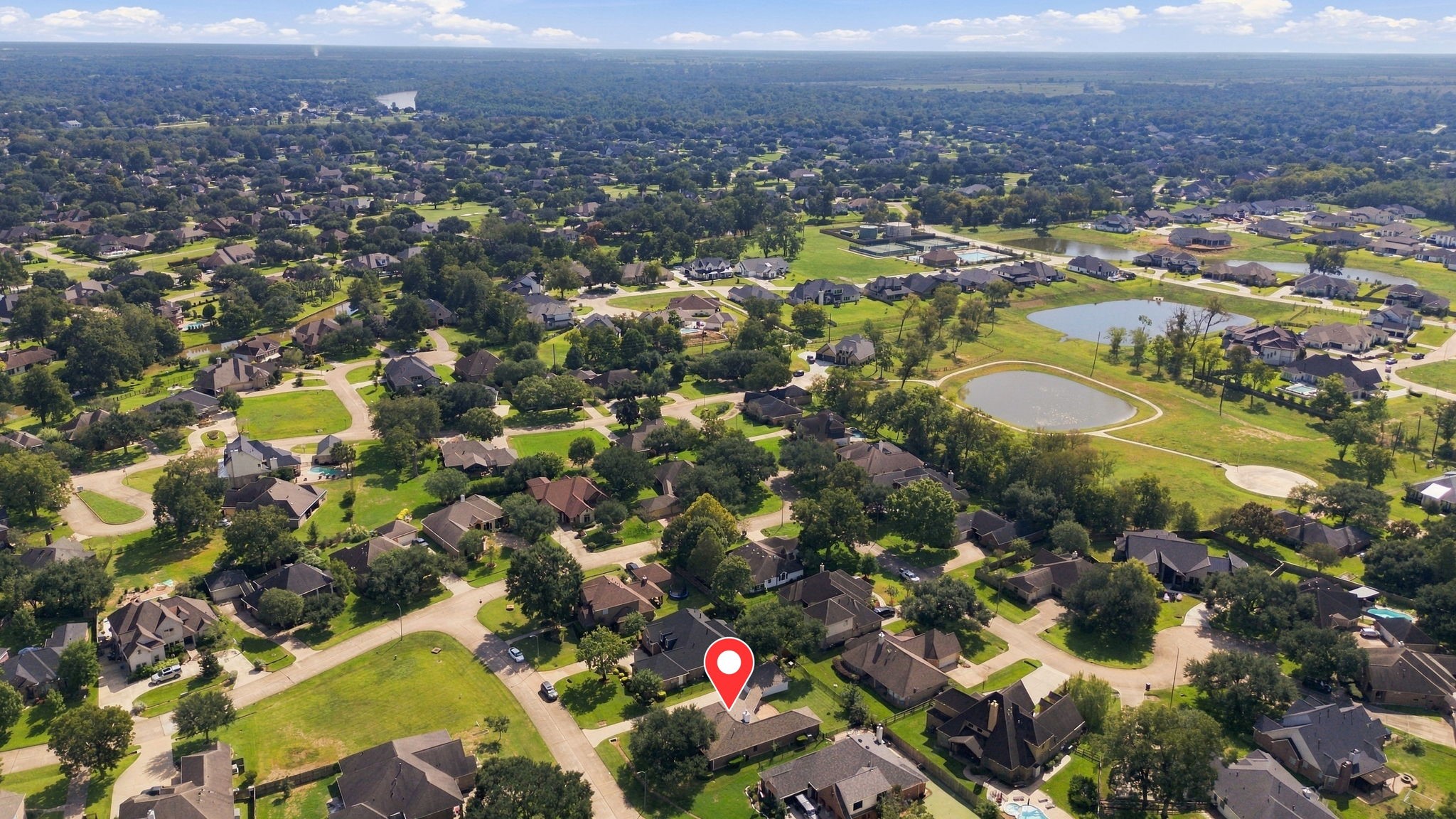 This aerial view is looking south and showcases the surrounding area, with the home pinpointed for easy reference and a clear perspective of its desirable location within Weston Lakes.