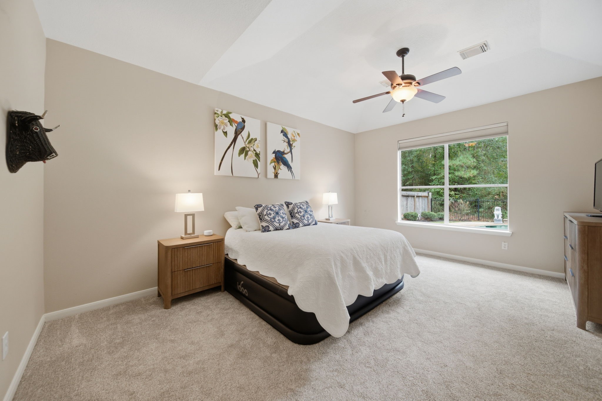 This spacious master retreat features soft neutral decor, a ceiling fan, and a large window with privacy shades overlooking the beautiful pool and back yard. Natural light enhances this restful retreat, complemented by the beautifully updated adjoining master bath. There's a walk-in closet in the bedroom too.