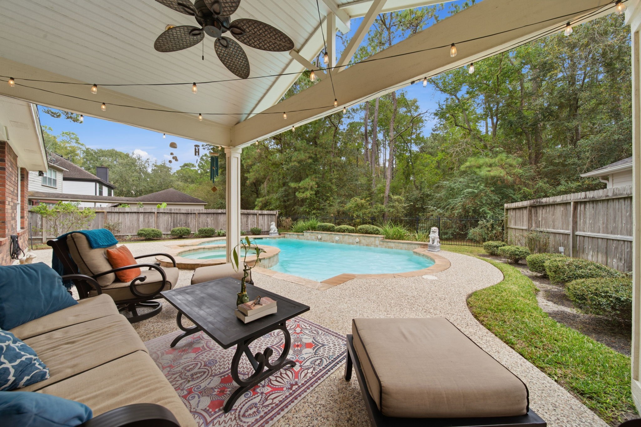 A fantastic addition to the home, this spacious covered patio offers an inviting spot to relax or entertain, overlooking the modern designed pool & spa. A vaulted ceiling, ceiling fan, and string lighting create a fun setting, especially at night. The wrought iron fencing along the back preserves the wooded views. This is a wonderful place to enjoy morning coffee or evening wine-down while you enjoy watching nature put on a show.