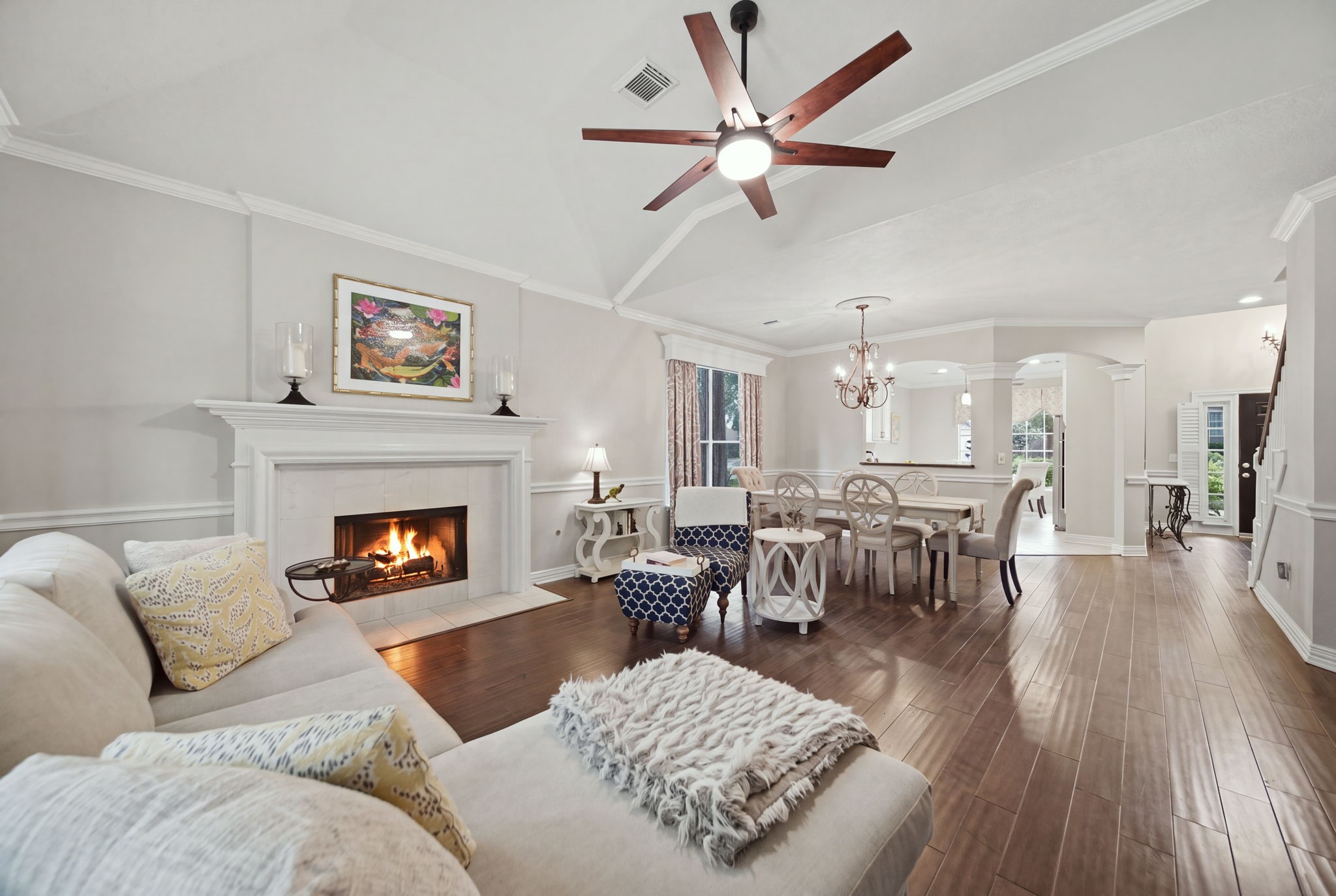 Rich wood floors, crown molding, and a beautifully trimmed fireplace bring warmth and character to this spacious living area. Enjoy the convenience of the gas logs or use the fireplace for wood-burning fires, if that's your preference. The adjoining dining space and owner-added opening to the kitchen create and inviting flow for entertaining, while custom window trim and abundant natural light complete the setting.