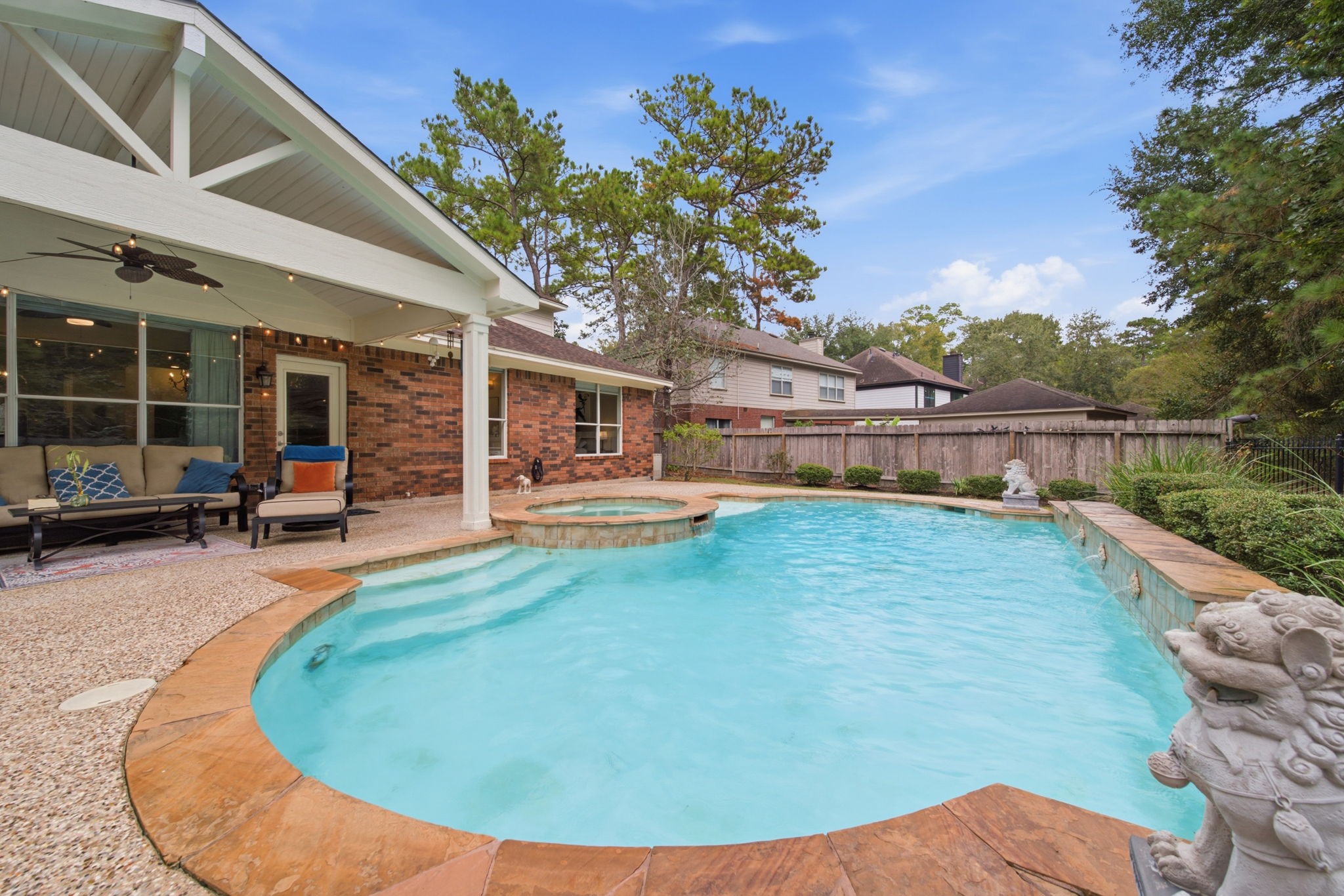 This stunning backyard oasis features a sparkling pool with a spa, surrounded by lush greenery and a spacious covered patio perfect for entertaining. The best part is that it's on a true greenbelt. It's such a serene place to unwind!
