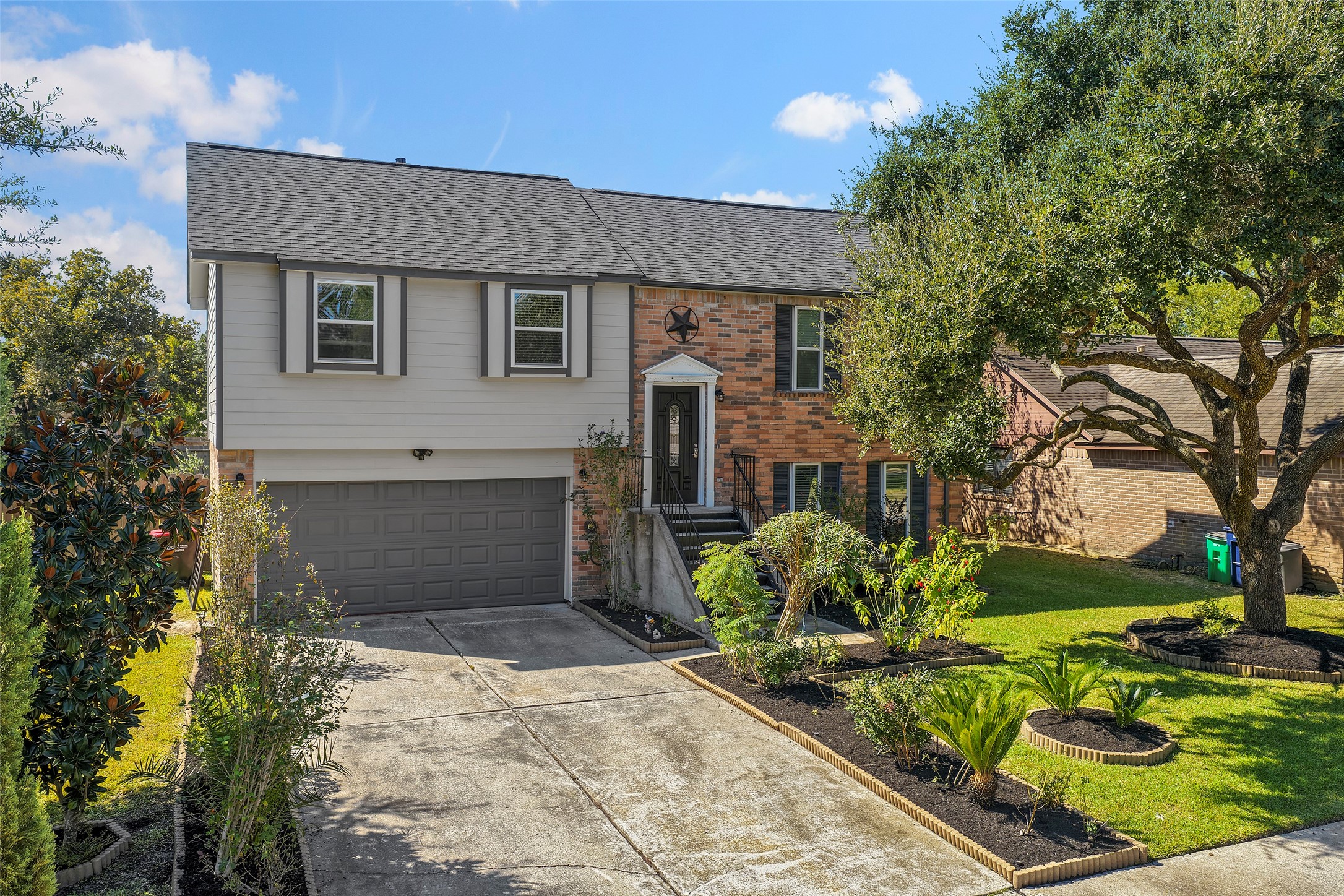 Freshly landscaped front yard with neatly trimmed plants and mature trees