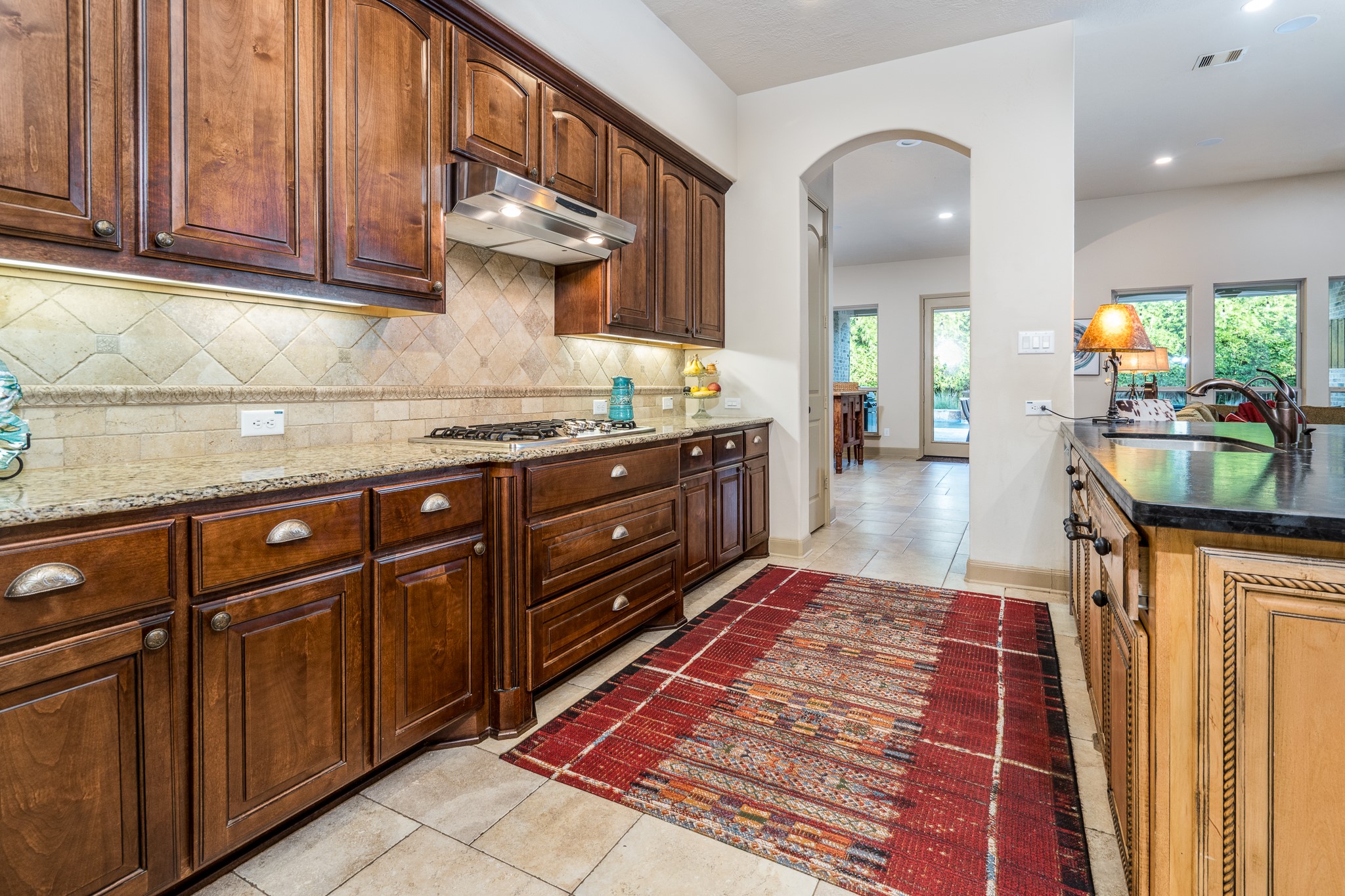 A culinary masterpiece! This beautifully gourmet kitchen showcases a stunning oversized island with luxurious leather-finished granite, gleaming granite countertops, abundant cabinetry, and elegant designer finishes.