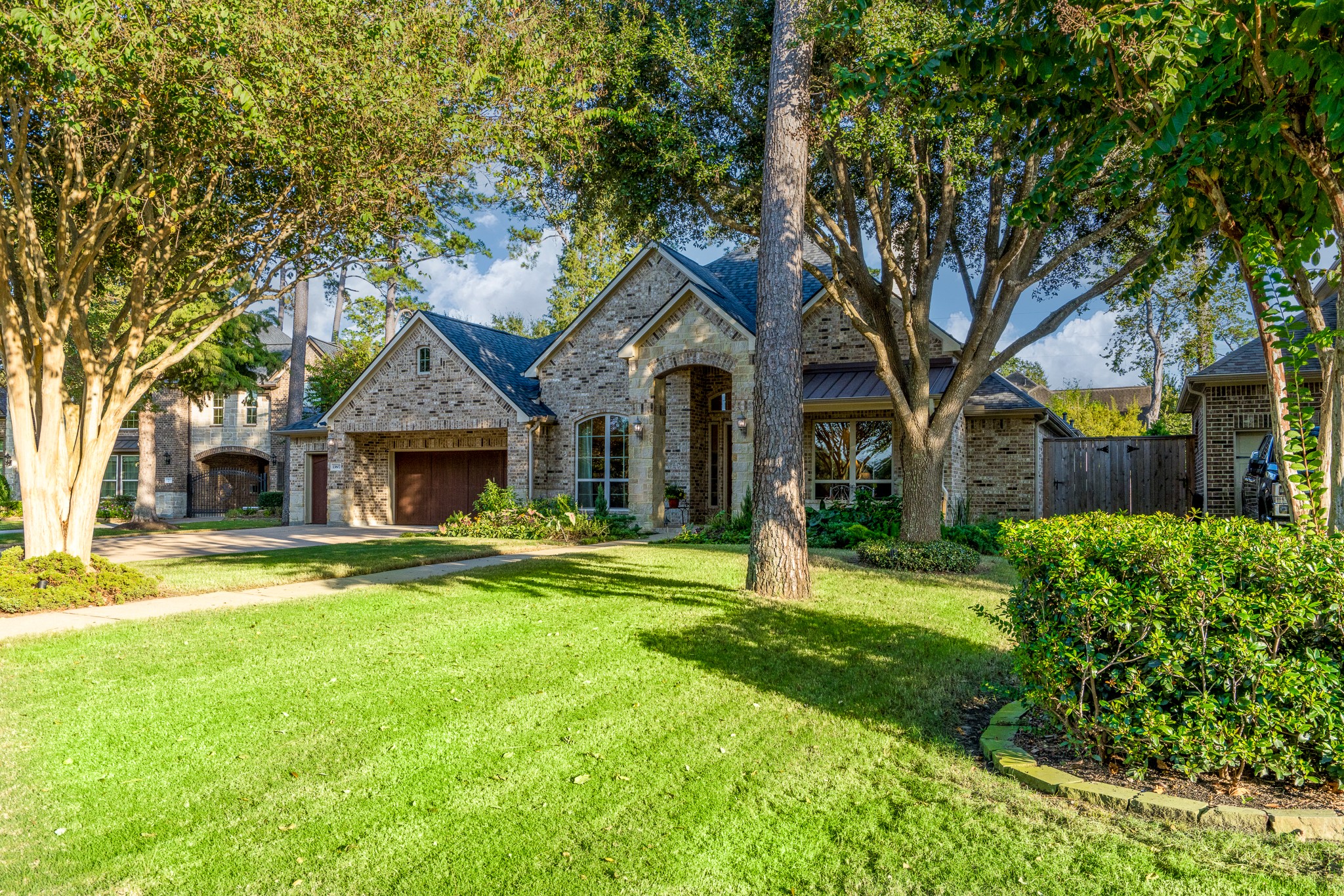 WHERE TIMELESS ELEGANCE MEETS THE BEAUTY OF NATURE! Nestled among majestic mature trees and lush, professionally landscaped grounds, this exquisite J. Patrick semi-custom home offers an enchanting sense of tranquility and privacy. Its stunning stone-and-brick architecture, sprawling green lawn, and picturesque setting create a captivating first impression in the prestigious gated community of White Oak Lake Estates. A place you'll be proud to call home!