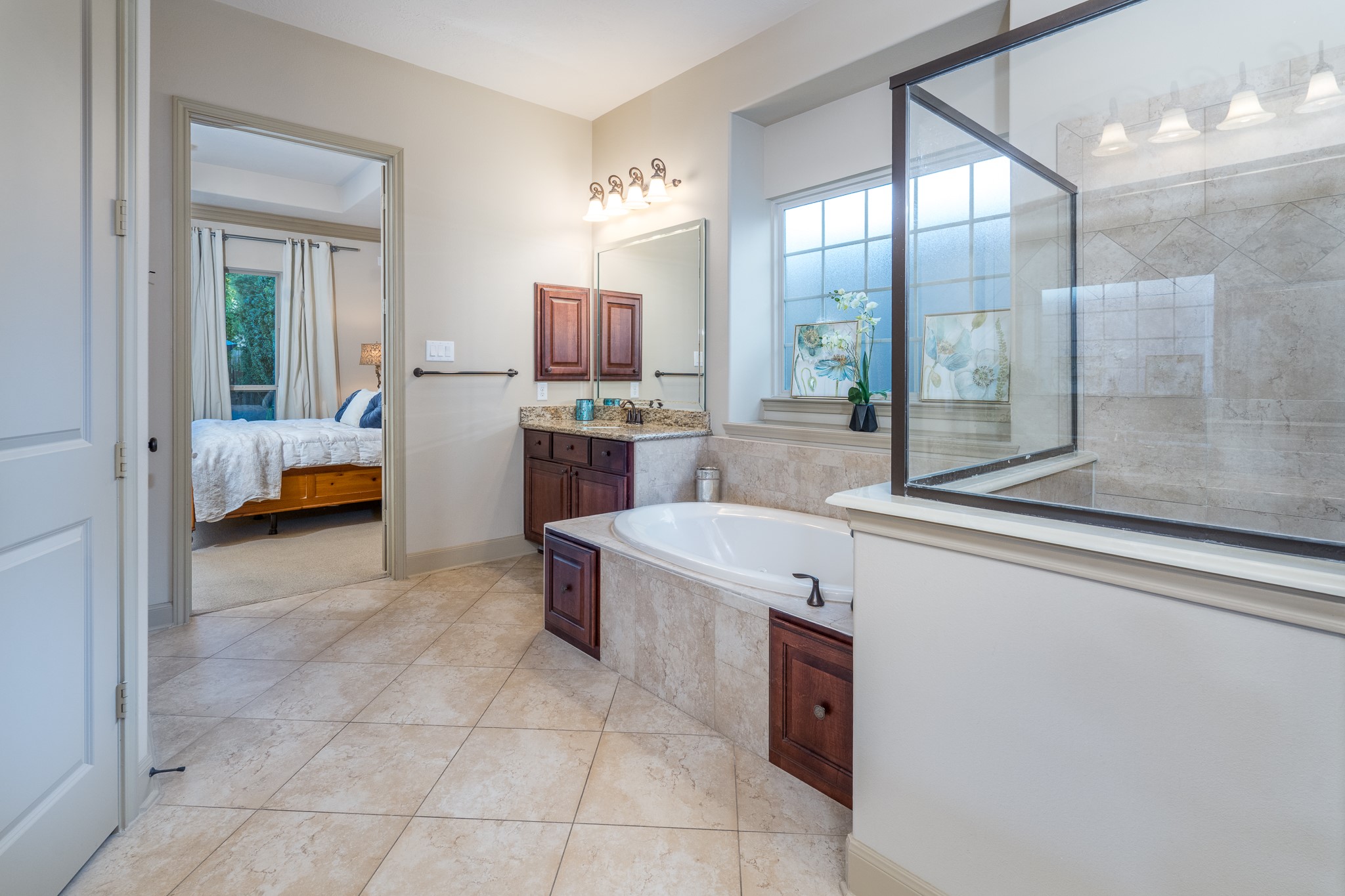 YOUR OWN PRIVATE SPA EXPERIENCE, JUST STEPS FROM YOUR BEDROOM! Imagine beginning each morning surrounded by natural light and ending each evening soaking away the day's stresses in your luxurious jetted tub. This beautifully designed primary ensuite features elegant stone finishes, a spacious glass-enclosed shower, and rich cabinetry with granite countertops. A peaceful sanctuary where everyday moments become little luxuries and relaxation feels effortless!