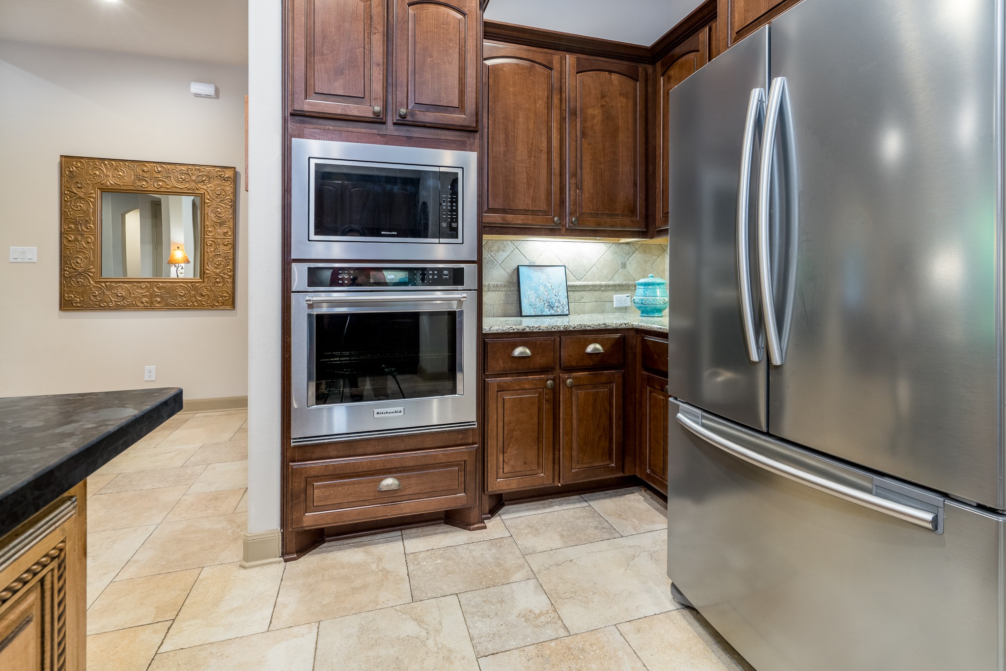 A kitchen designed for effortless elegance and everyday convenience! Rich wood cabinetry, beautiful stone countertops, and sleek stainless steel appliances create a timeless blend of warmth and sophistication. The built-in microwave and oven, generous storage, and thoughtfully designed layout make meal preparation a pleasure, while the open connection to the adjoining living spaces makes entertaining family and friends effortless.