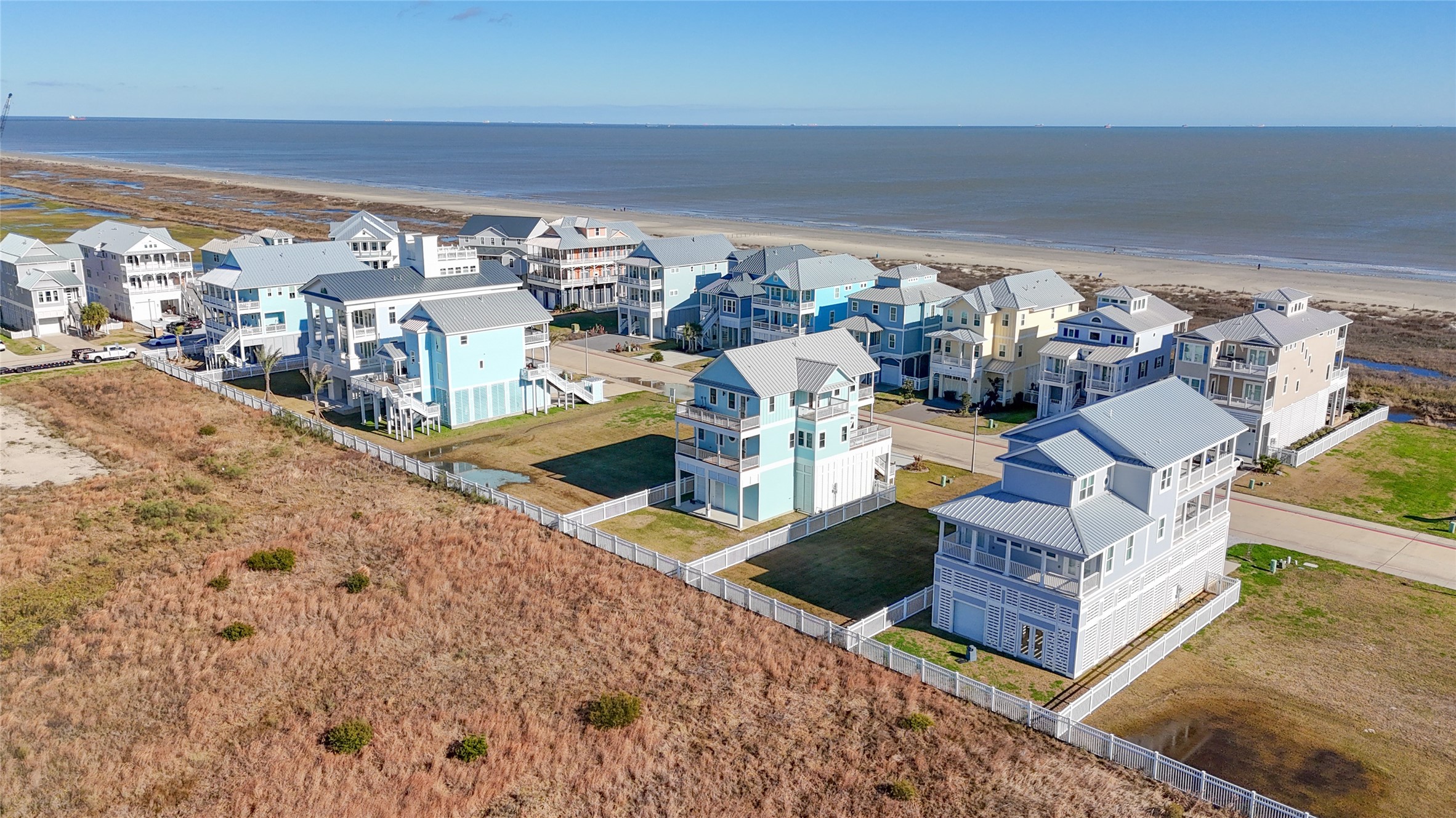 This aerial perspective places the homesite in context with both the Gulf and neighboring residences, demonstrating its desirable second-row location within The Preserve at Grand Beach. The property sits just across the street from beach access and is surrounded by substantial coastal homes, offering an increasingly rare opportunity to build new construction on Galvestons East End while remaining only minutes from The Strand. This aerial perspective places the homesite in context with both the Gulf and neighboring residences, demonstrating its desirable second-row location within The Preserve at Grand Beach. The property sits just across the street from beach access and is surrounded by substantial coastal homes, offering an increasingly rare opportunity to build new construction on Galvestons East End while remaining only minutes from The Strand.
