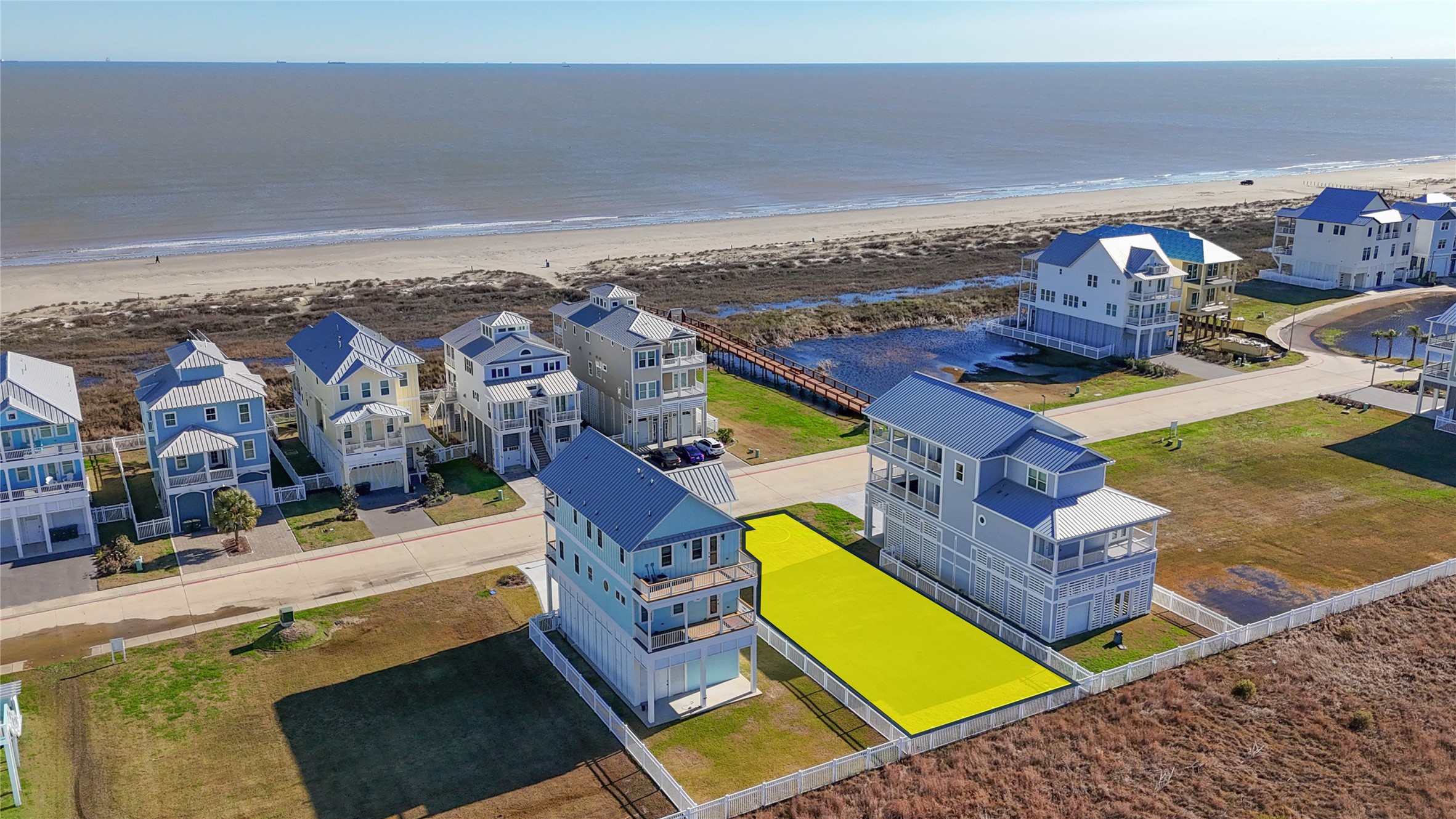 Looking across the community toward the Gulf, this aerial view showcases the open setting surrounding the homesite and the impressive coastal residences already established nearby. The cleared building site offers a blank canvas for a thoughtfully designed custom home, with a 50-foot frontage and approximately 120 feet of depth providing flexibility for an elevated residence, outdoor living areas and coastal-oriented architecture. Looking across the community toward the Gulf, this aerial view showcases the open setting surrounding the homesite and the impressive coastal residences already established nearby. The cleared building site offers a blank canvas for a thoughtfully designed custom home, with a 50-foot frontage and approximately 120 feet of depth providing flexibility for an elevated residence, outdoor living areas and coastal-oriented architecture.