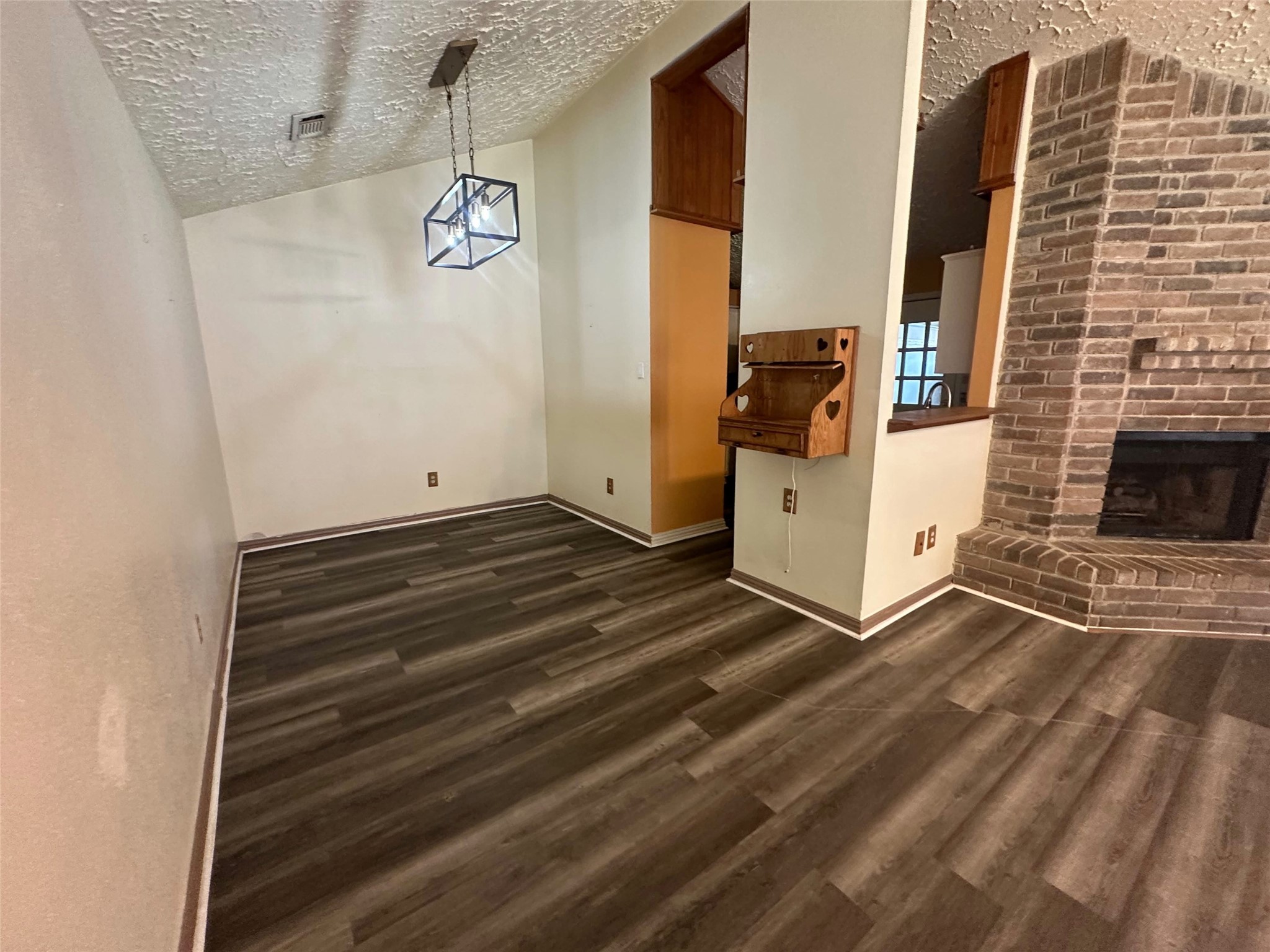 Bright open dining area with durable plank flooring, statement pendant, fixed wood hutch and brick-fireplace connection. Bright open dining area with durable plank flooring, statement pendant, fixed wood hutch and brick-fireplace connection.