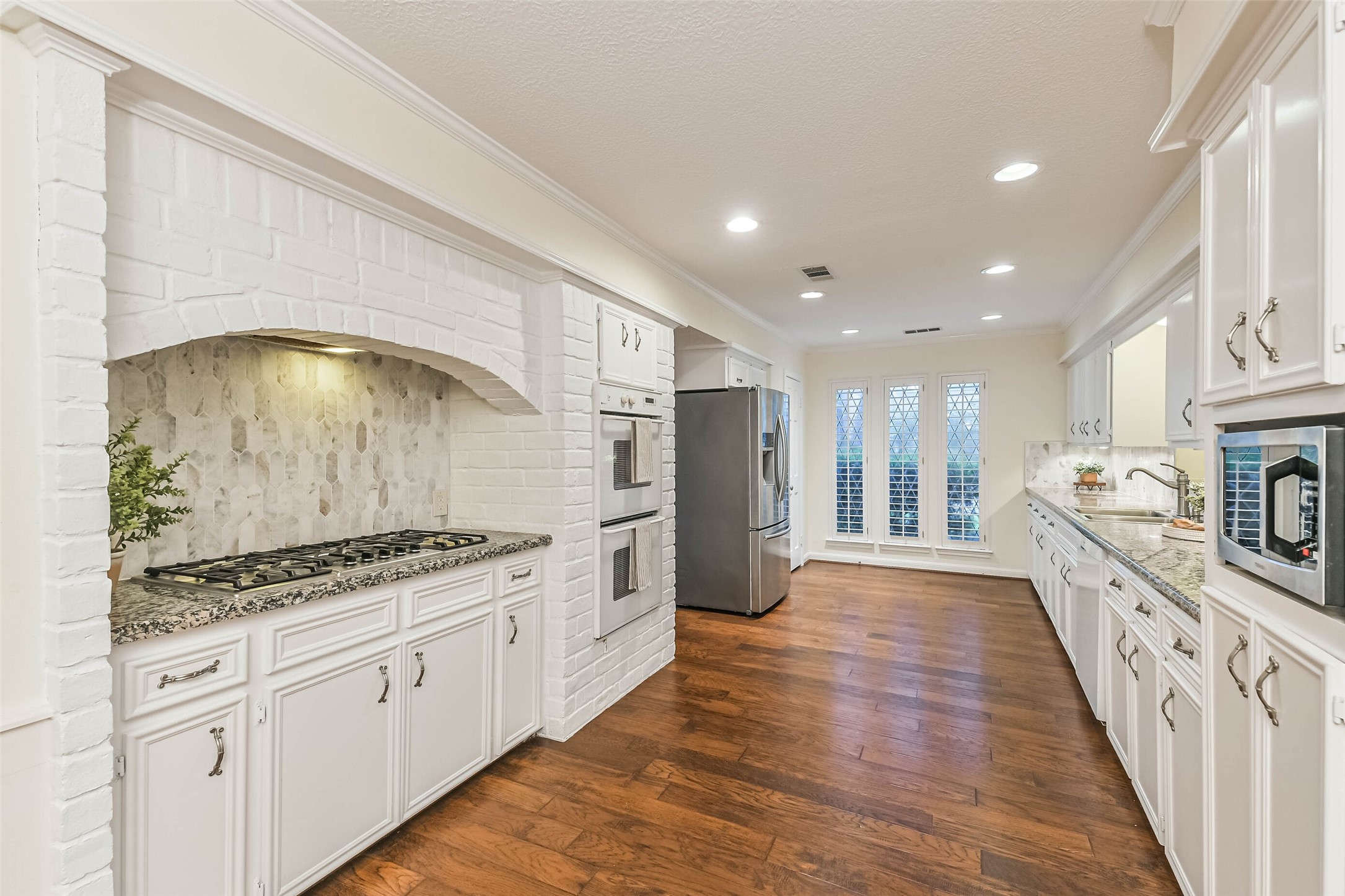 Long open kitchen with large stovetop, double ovens and long counter space. Long open kitchen with large stovetop, double ovens and long counter space.