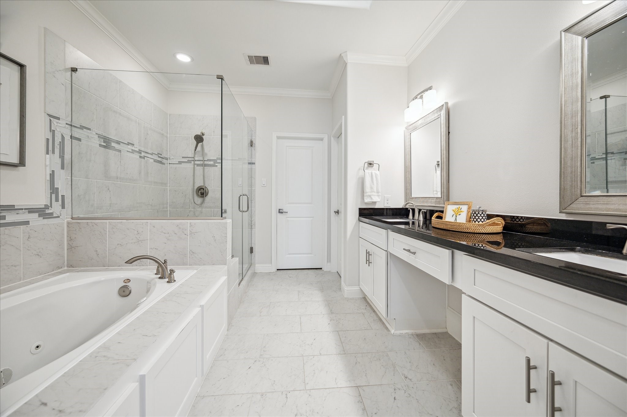 Primary bathroom features two vanities with a separate shower and jetted tub