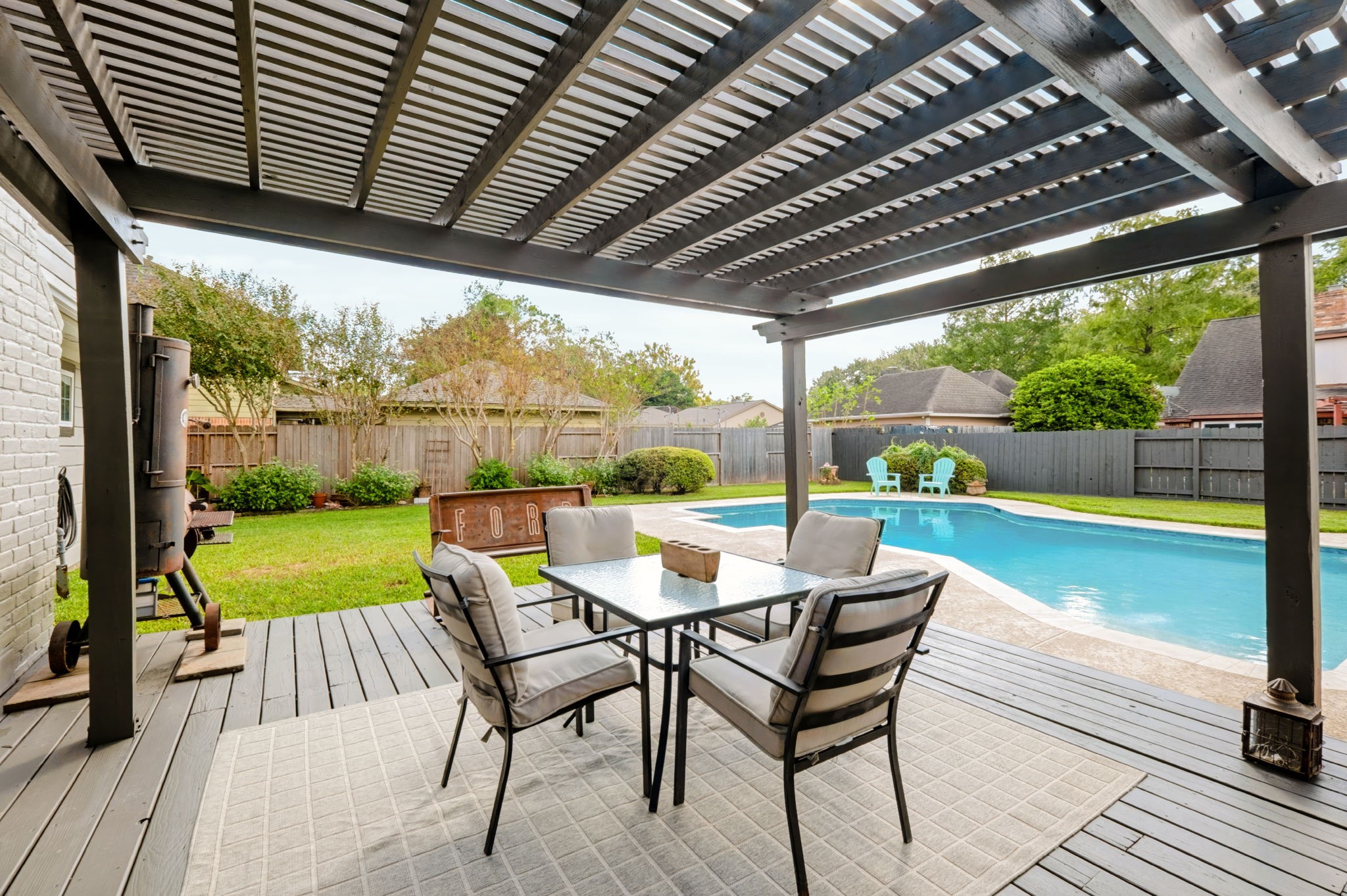 New covered deck overlooking the recently redone swimming pool, creating an inviting outdoor entertaining space with views of the private, fenced backyard.