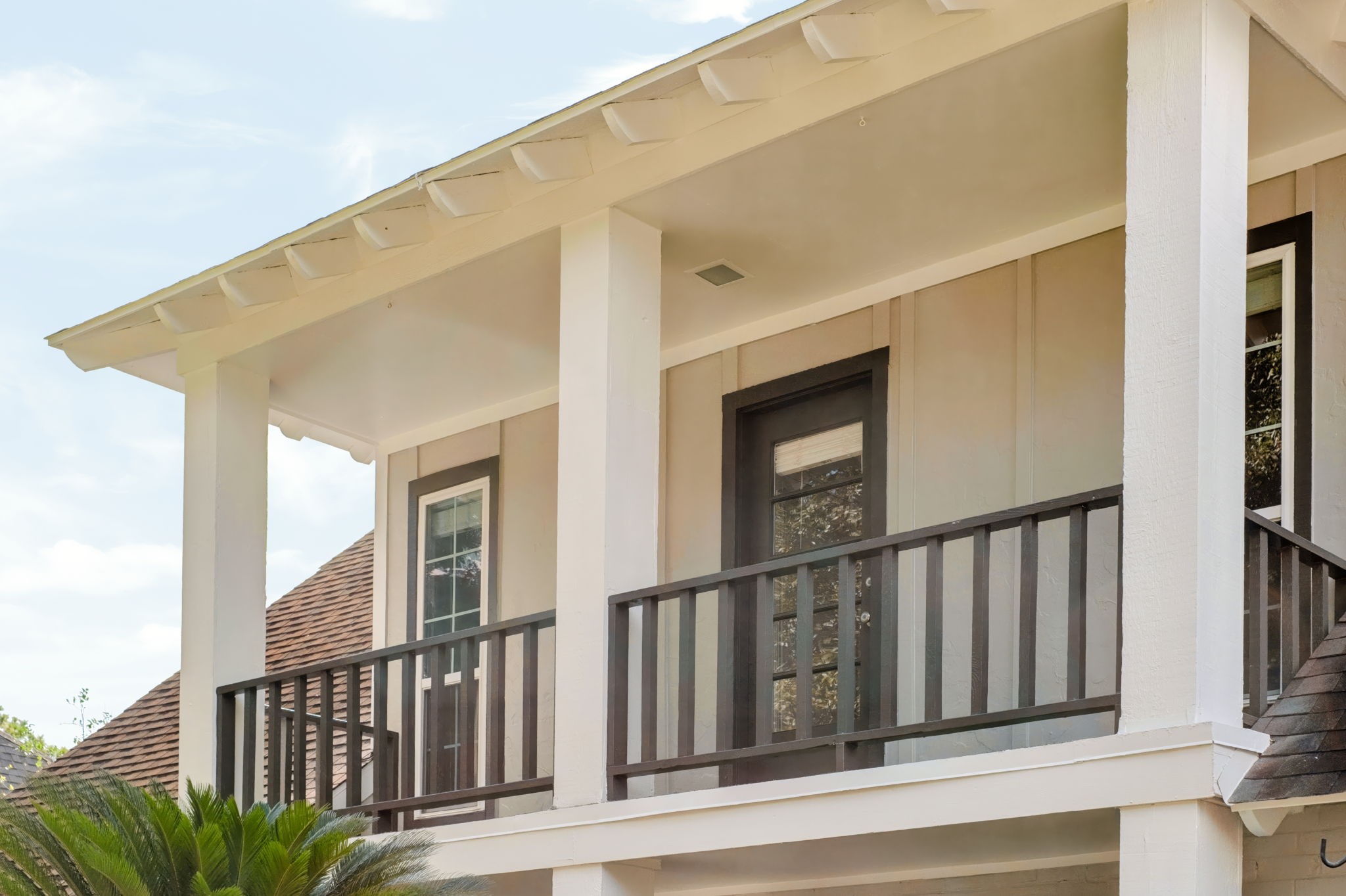 Upper-level balcony overlooking the front grounds, complemented by recently painted exterior surfaces and new Hardie plank siding.