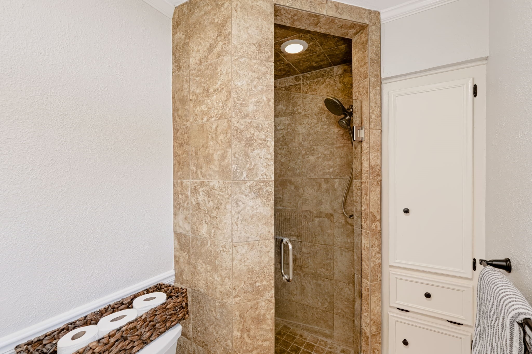 Walk-in shower with floor-to-ceiling tilework and a built-in niche.