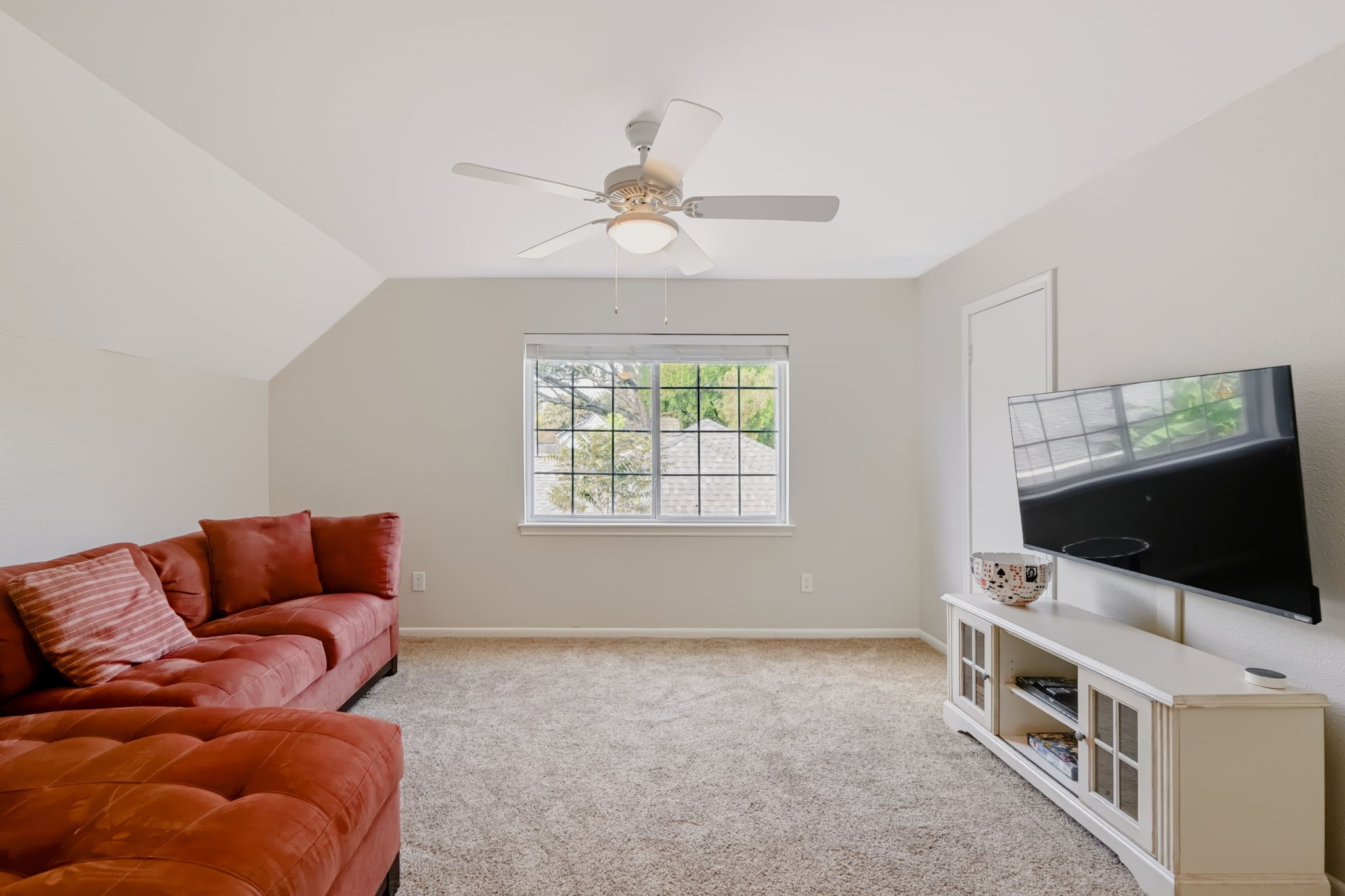 Versatile upstairs game room featuring new LED lighting, a ceiling fan, and flexible space for a media room, recreational activities, or additional living area.