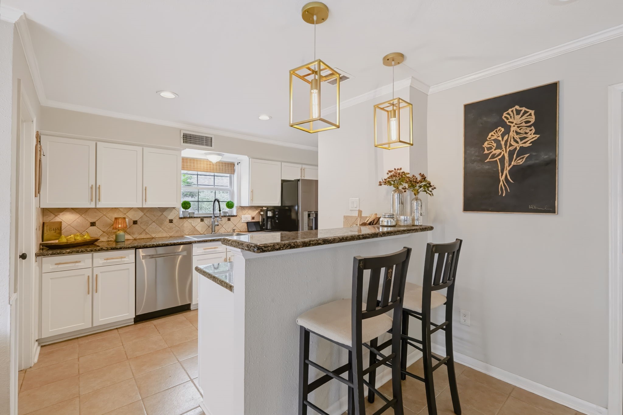 Functional kitchen featuring a convenient breakfast bar, generous countertop workspace, abundant cabinetry, and an easy connection to the adjoining dining area.