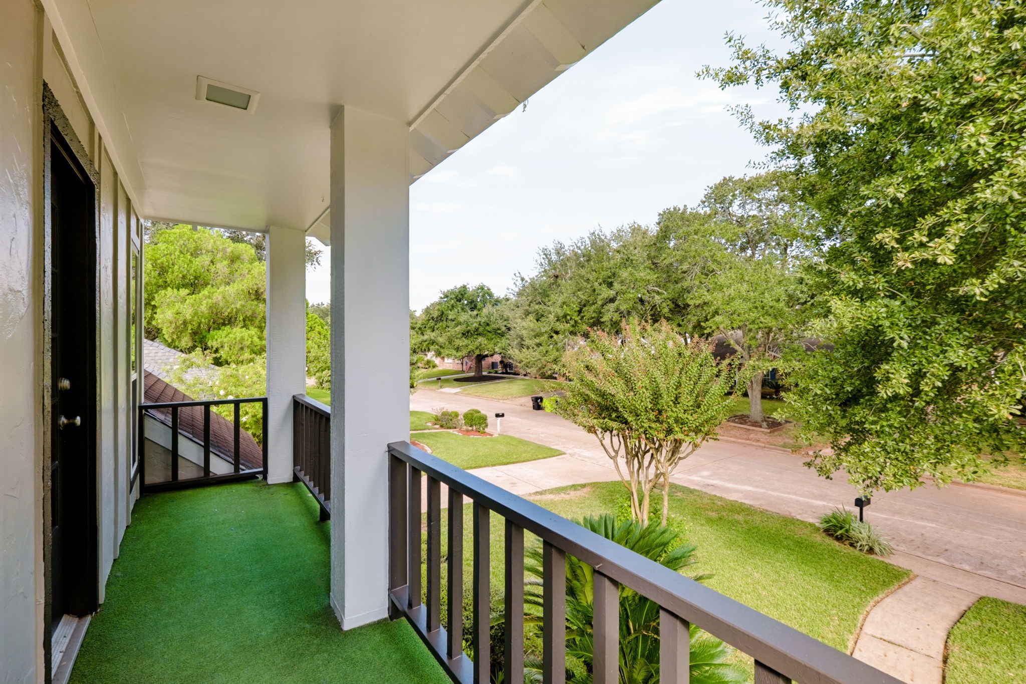 Covered upper-level balcony with a peaceful neighborhood view.