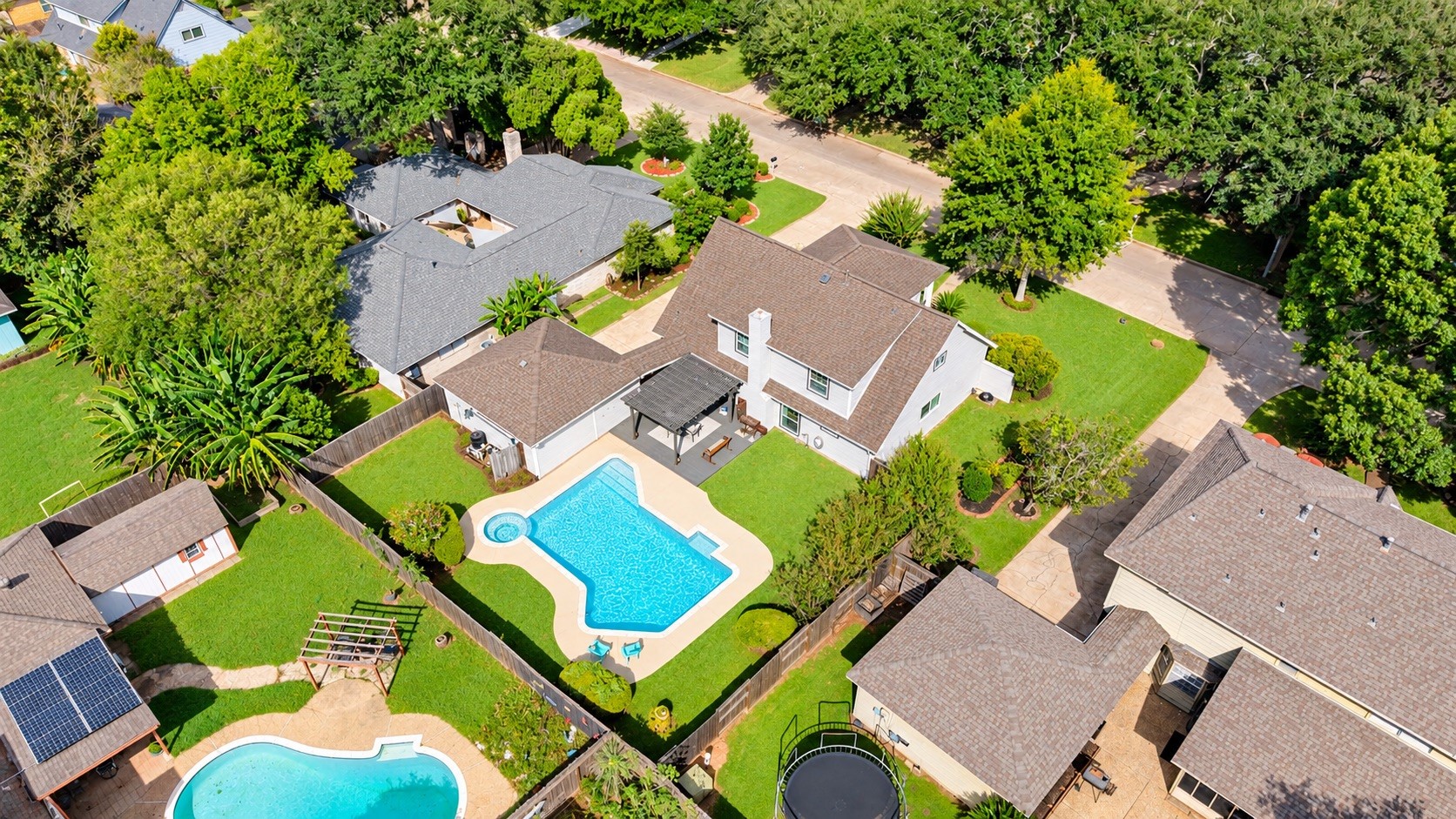 Elevated view showcasing the home, private backyard, and recently redone pool.