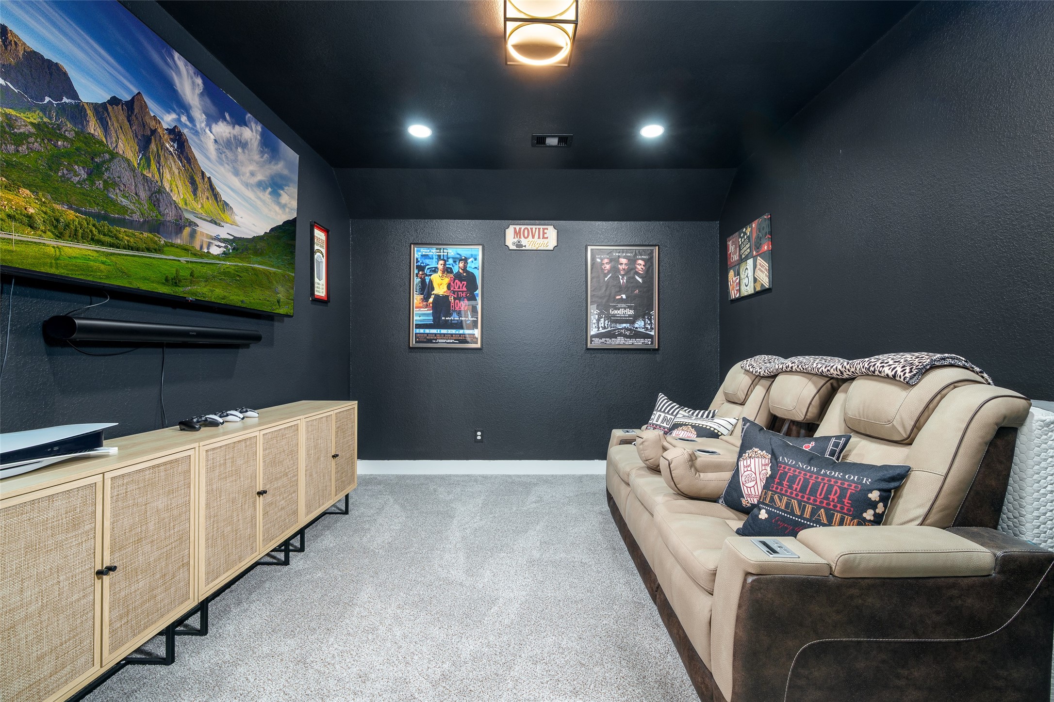 Enjoy movie nights in the cozy media room, complete with plush carpet, recessed lighting for the perfect ambiance, and dark custom paint.