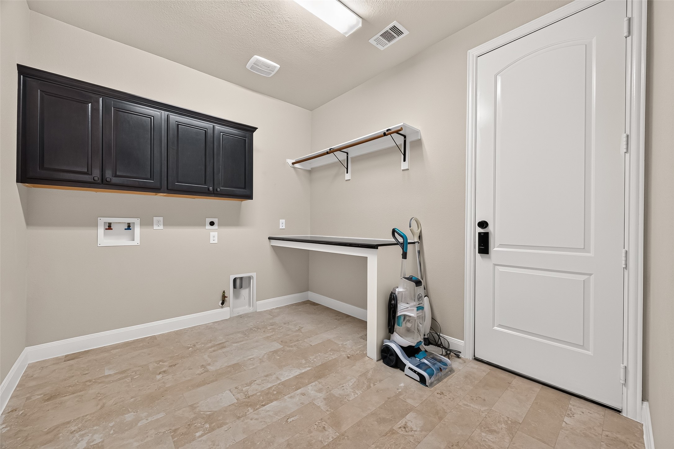 Downstairs Laundry Room: The spacious main laundry room is thoughtfully designed with built-in countertops, hanging racks, and extra cabinets for exceptional storage.