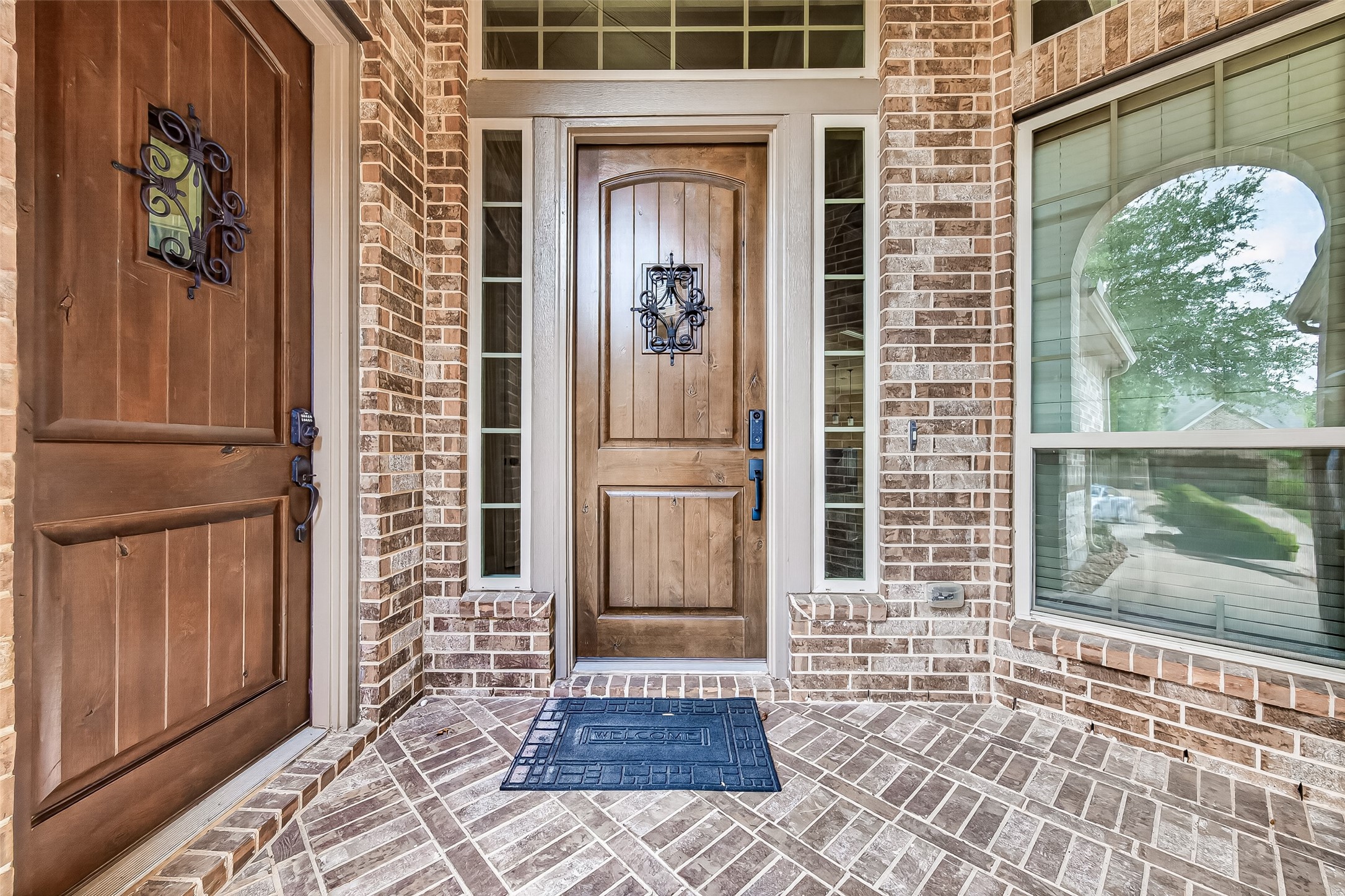 Front Porch: A welcoming front porch with elegant dual wood front doors featuring wrought iron detailing sets the tone for the sophistication found throughout. Front Porch: A welcoming front porch with elegant dual wood front doors featuring wrought iron detailing sets the tone for the sophistication found throughout.